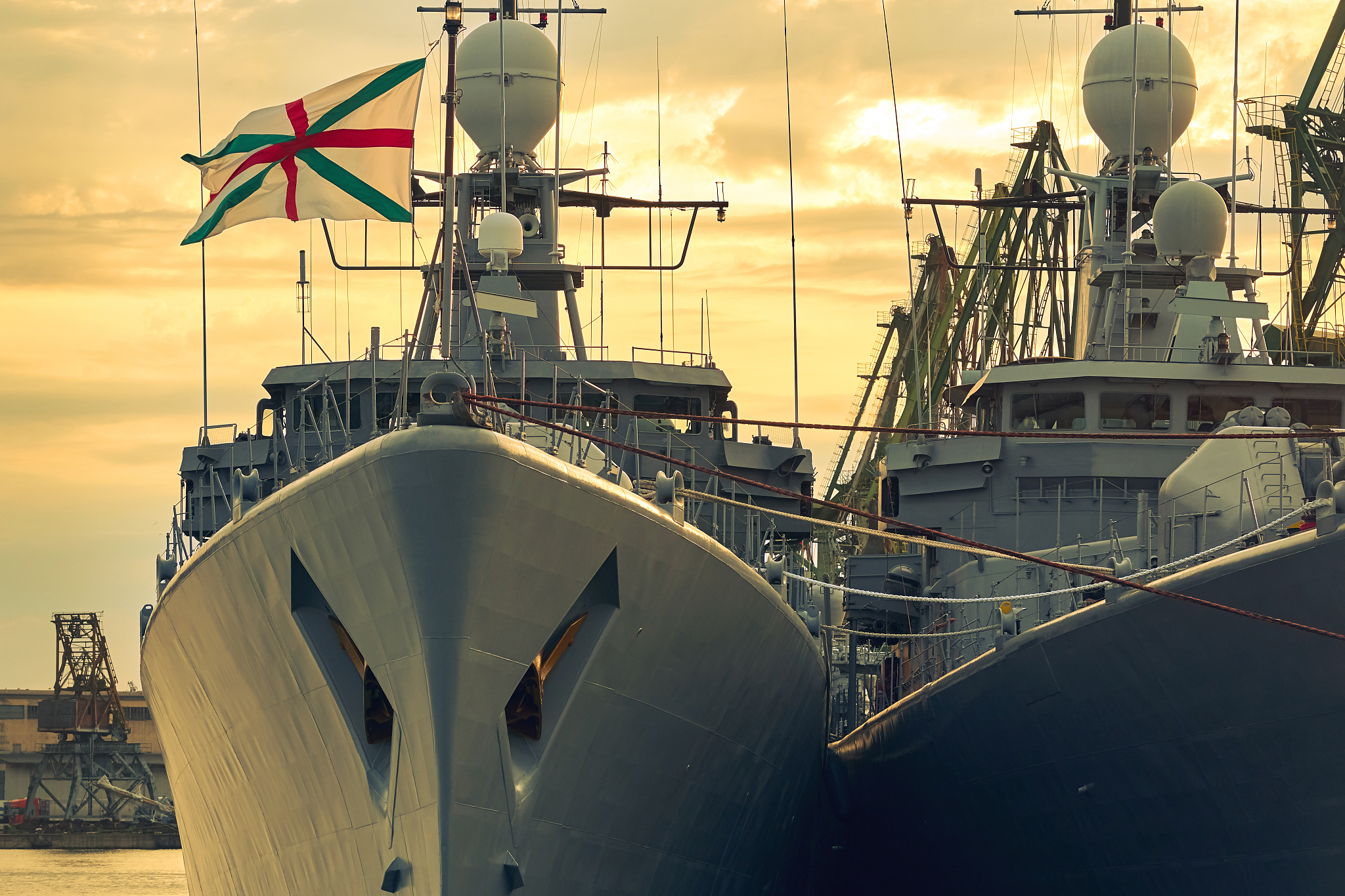 maritime city port. fragment of a warship on the quay on the sun