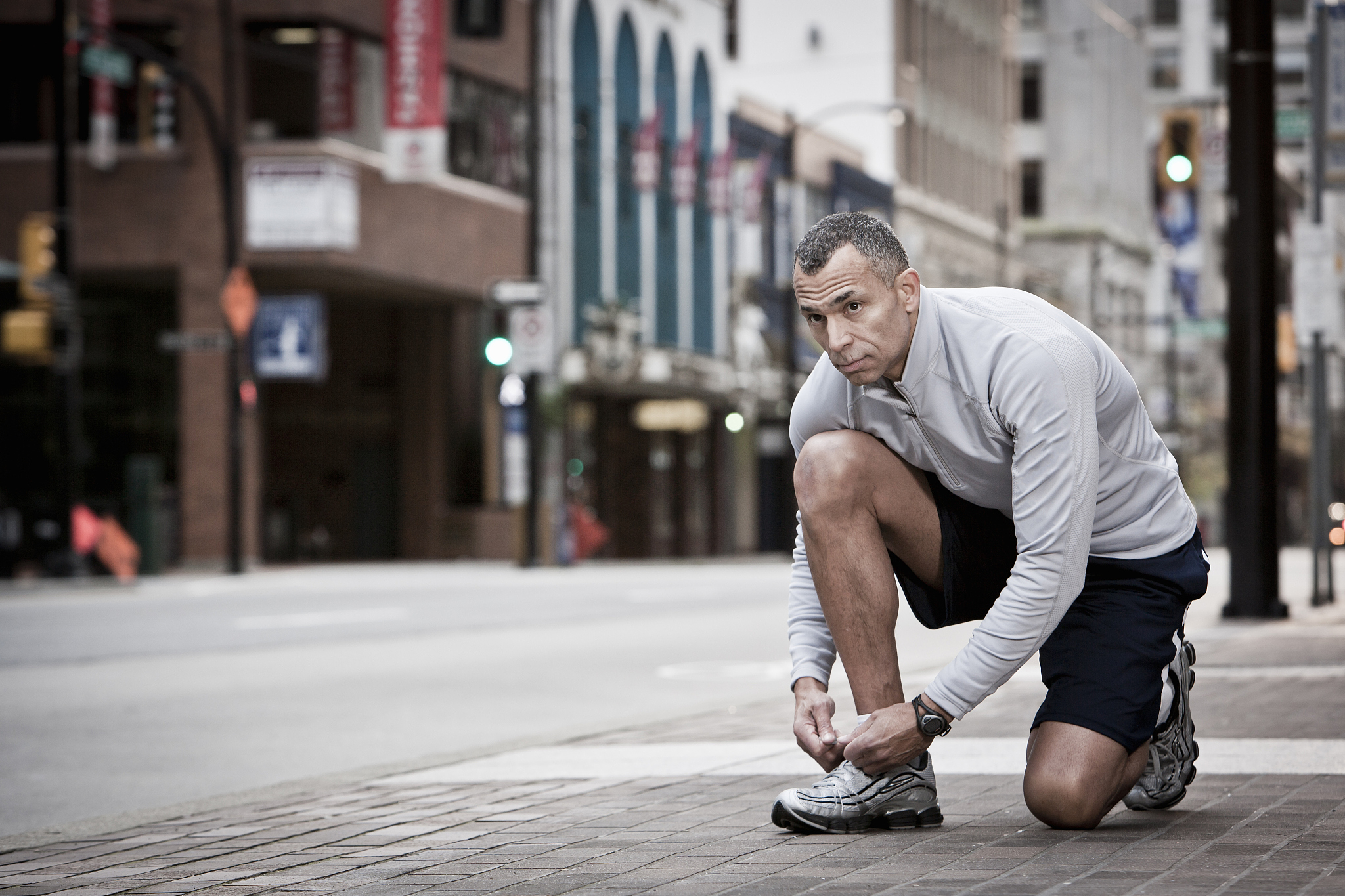a runner stops to tie his shoe