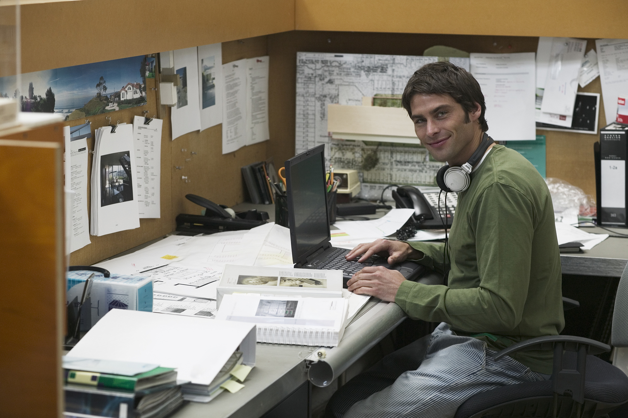 man with headphones at desk, portrait