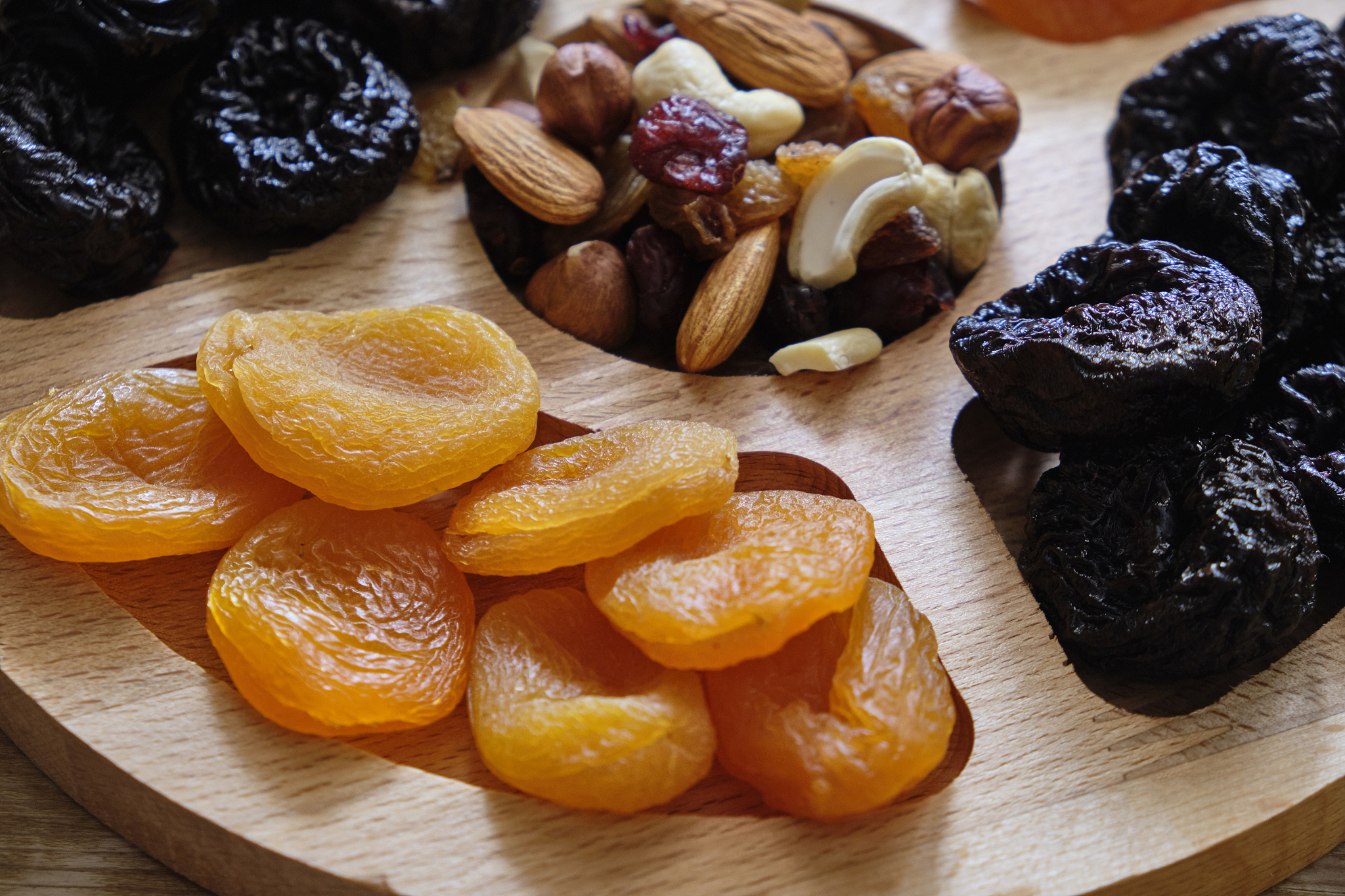 dried apricots, prunes and nut mix at weathered wooden backgroun