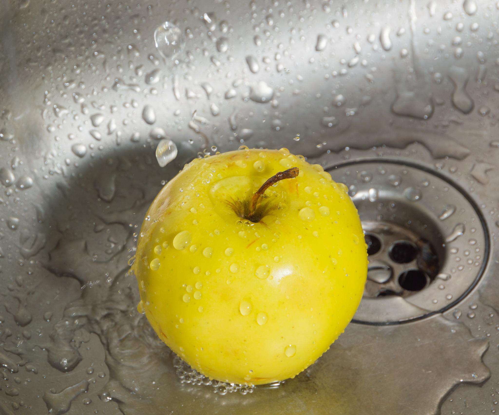in the sink at the water drops yellow apple