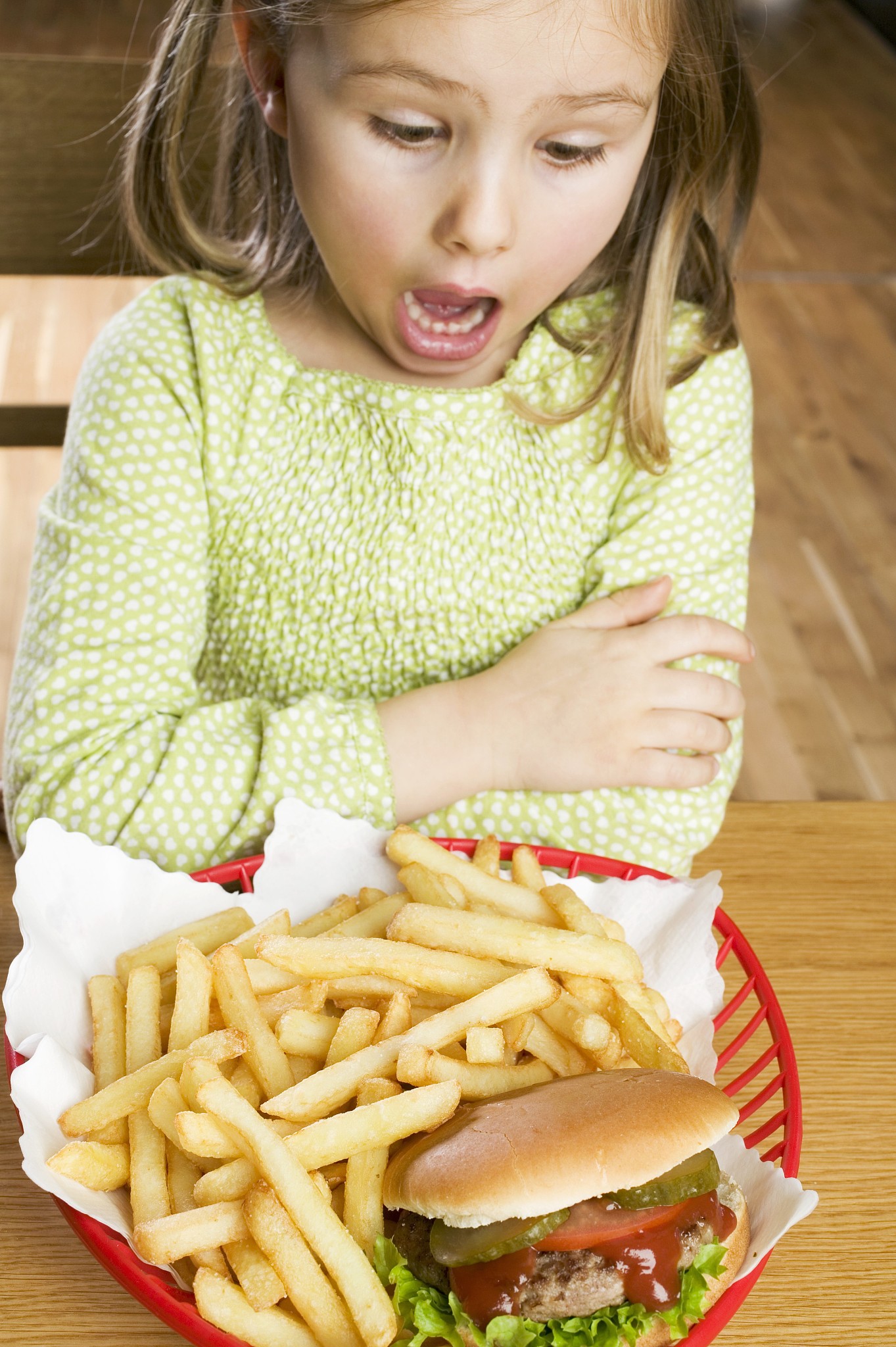 horrified girl looking at hamburger and chips