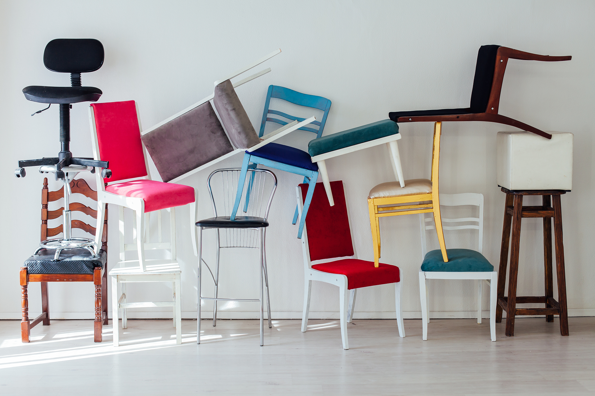 different multicolored chairs in the interior of the white room