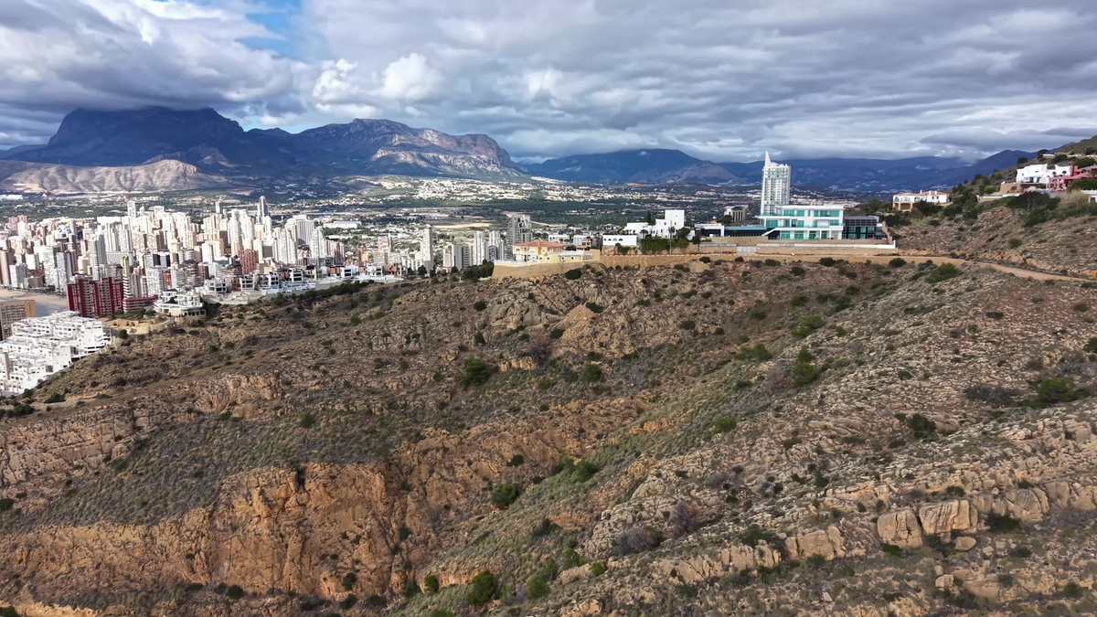 丘陵地貌,远眺城市,宁静的岩石斜坡,背景是远处的城市