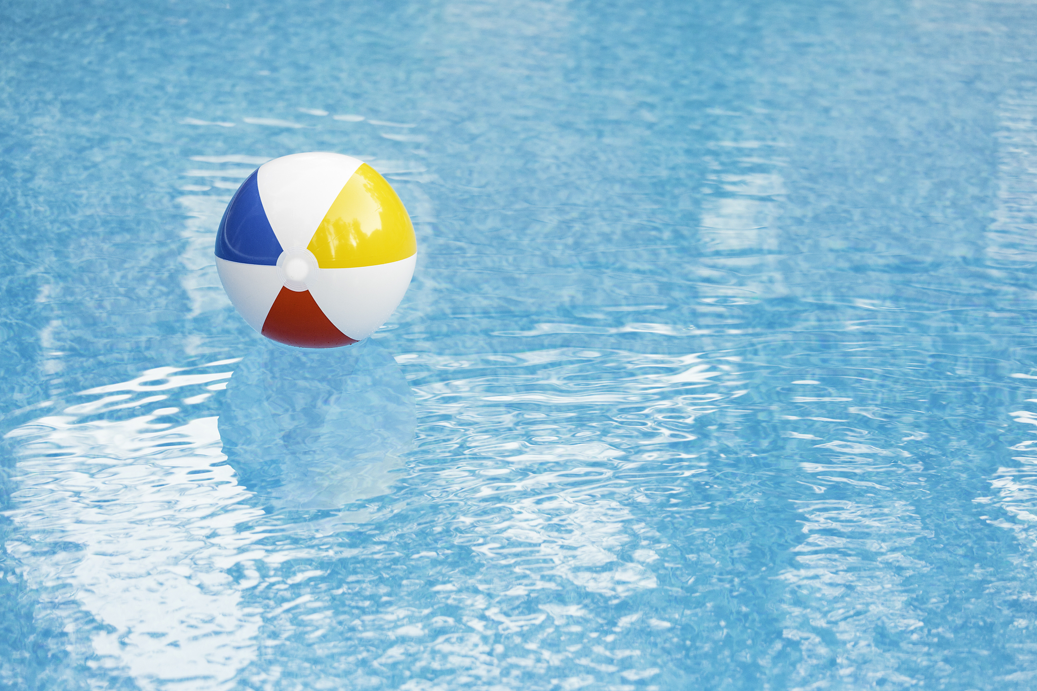bright beach ball in deserted pool