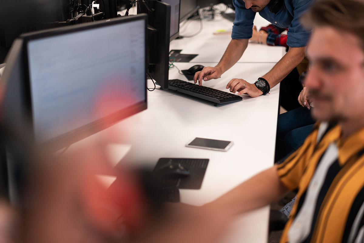 一群休闲的商人在现代开放式的启动办公室内部的台式电脑上工作.有选