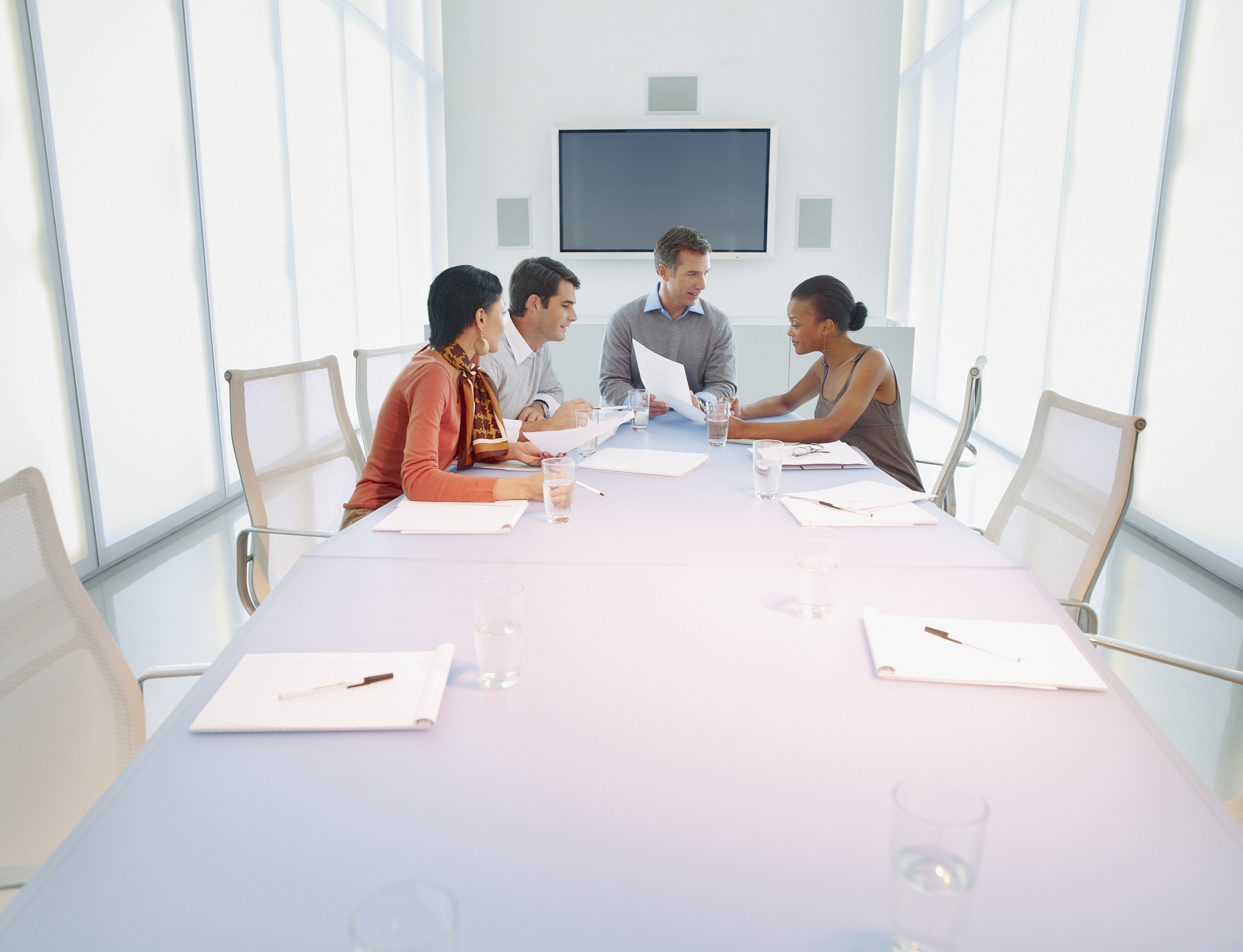 four businesspeople in boardroom working