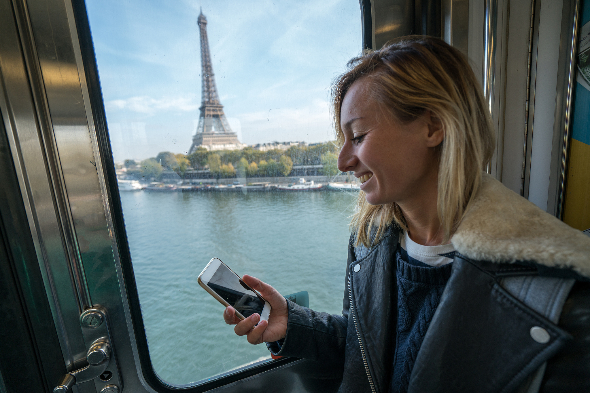 girl reading message on phone while on paris metro