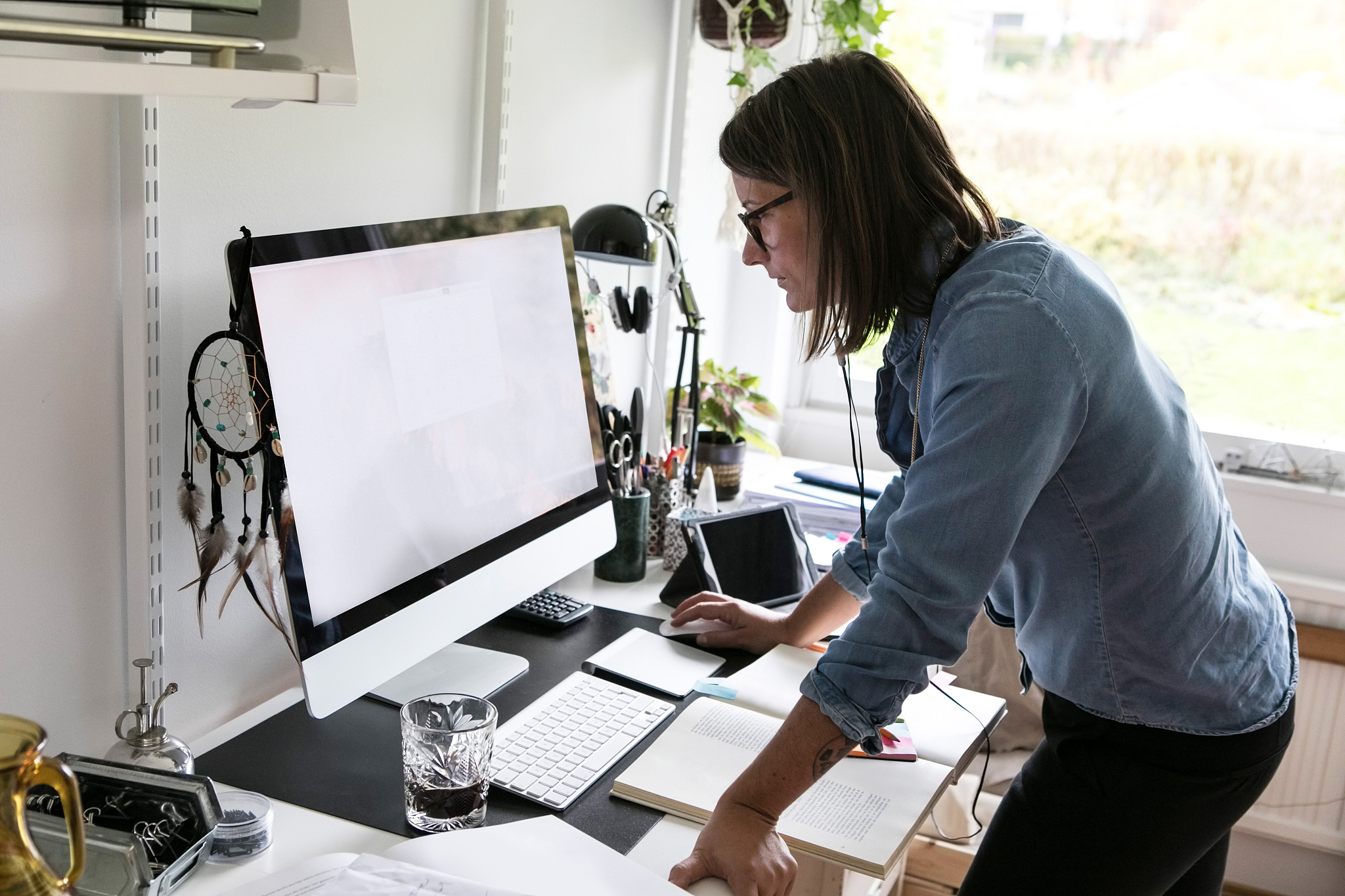 side view of businesswoman using computer while standing at home