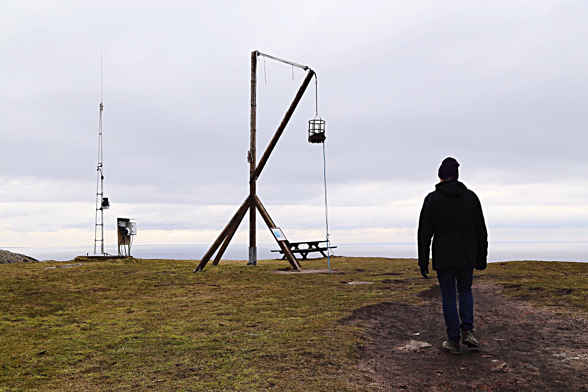 rear view of person standing by fireplace on field against sky