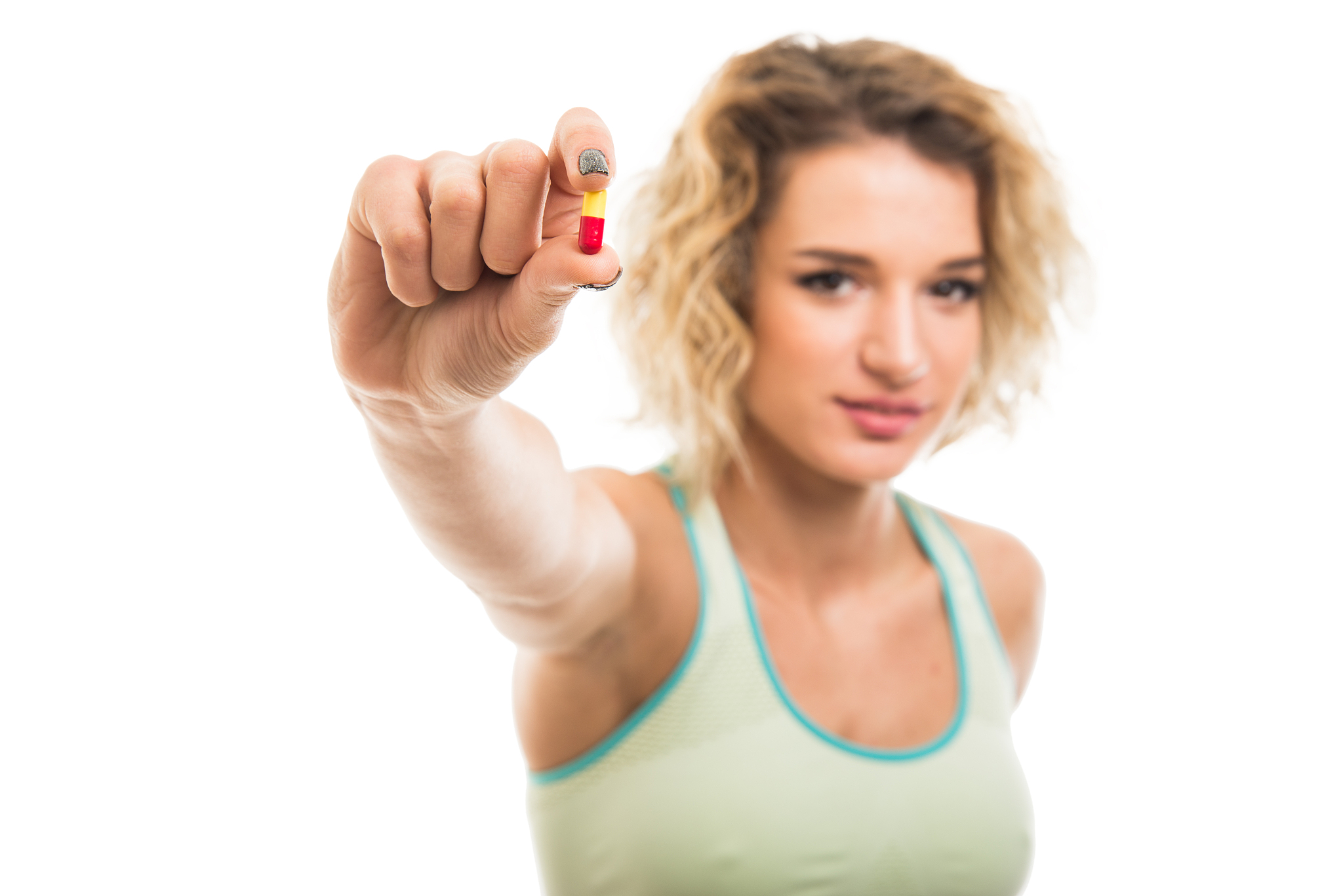 selective focus of beautiful young fit girl showing one pill