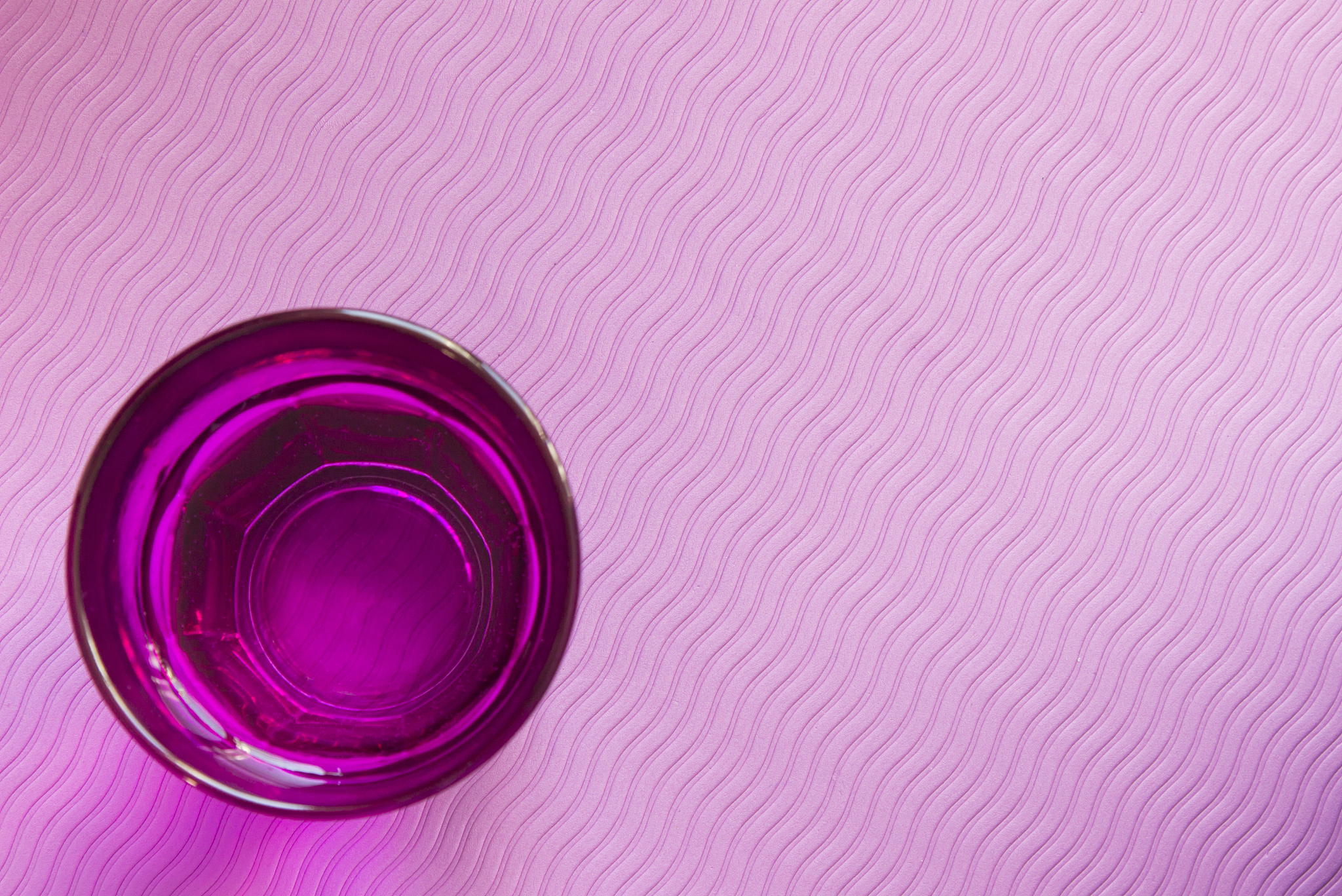 glass of water with a purple fitness , yoga mat . healthy lifest