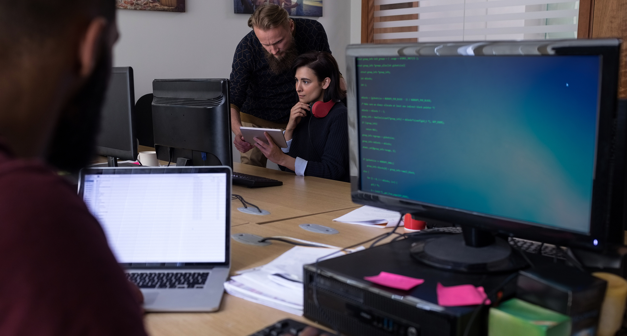 colleagues using digital tablet while working at desk