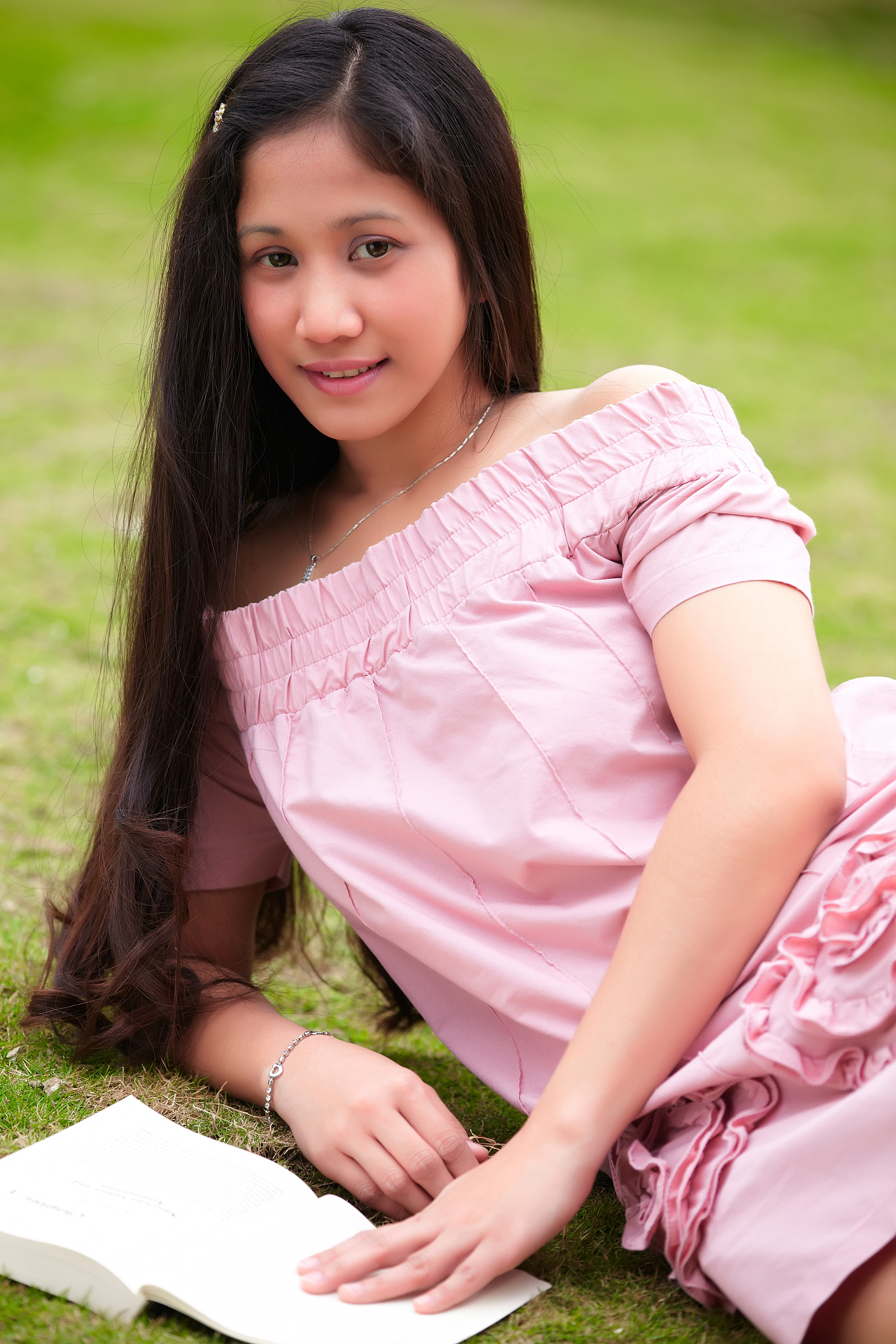 beautiful asian woman learning on grass