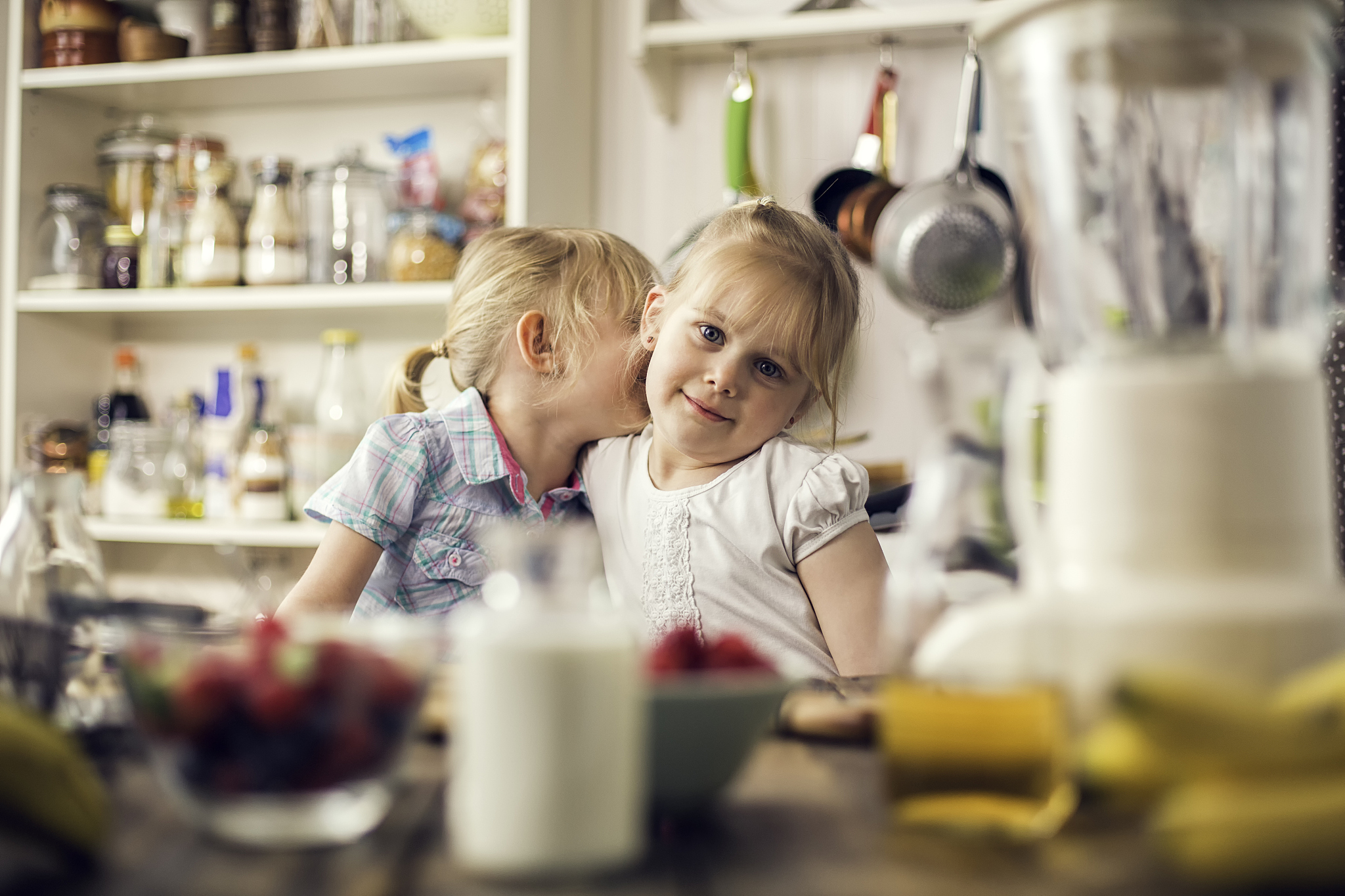 two little girls having fun in preparing smoothies
