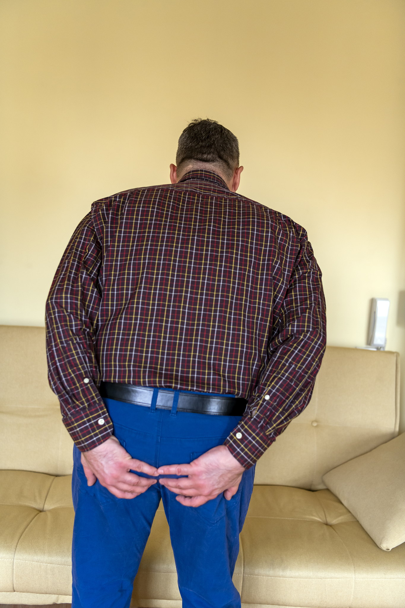 man with hemorrhoids holding his ass in pain