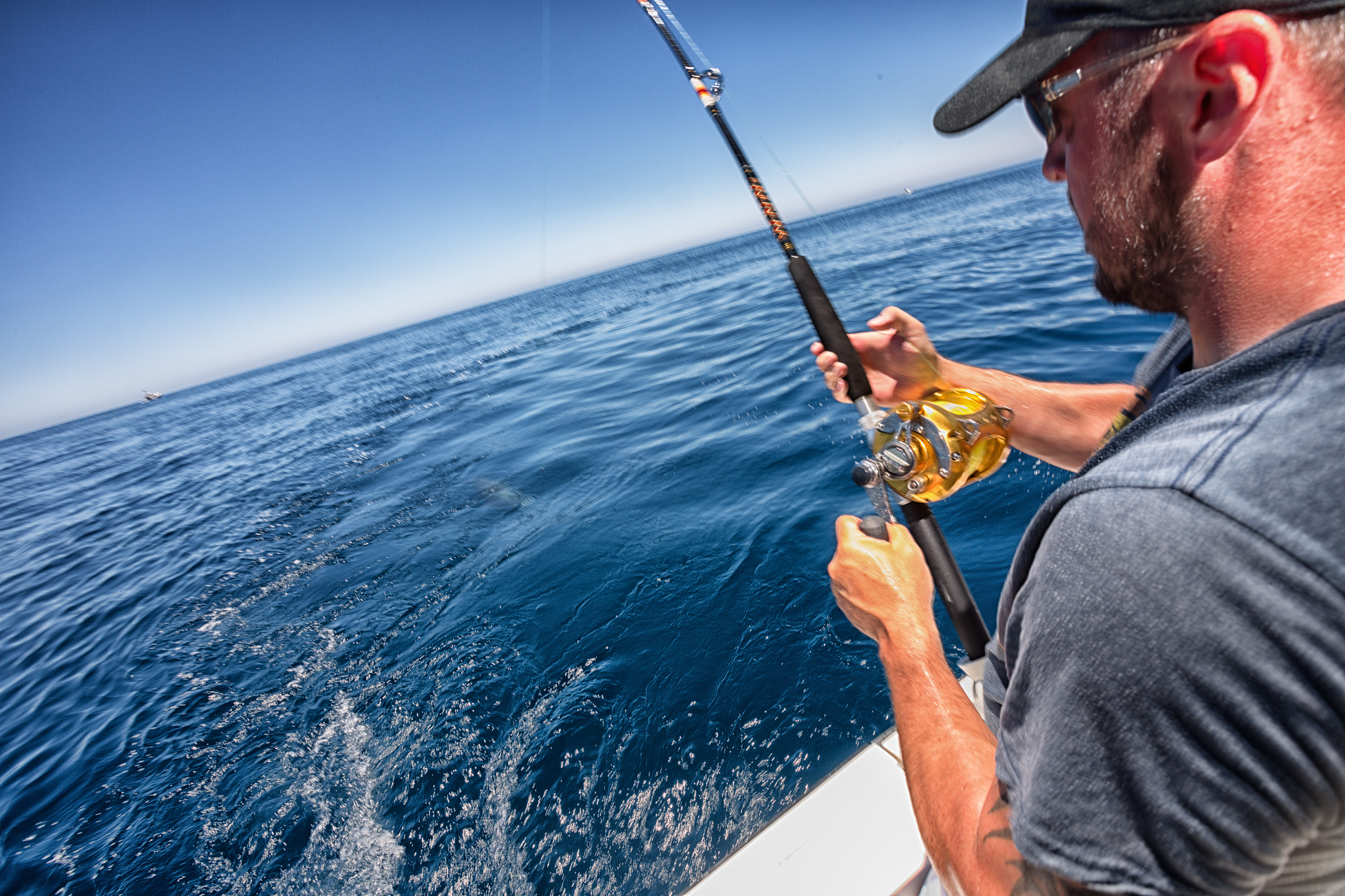 描写一段大海中男人在轮船上钓鱼的场景