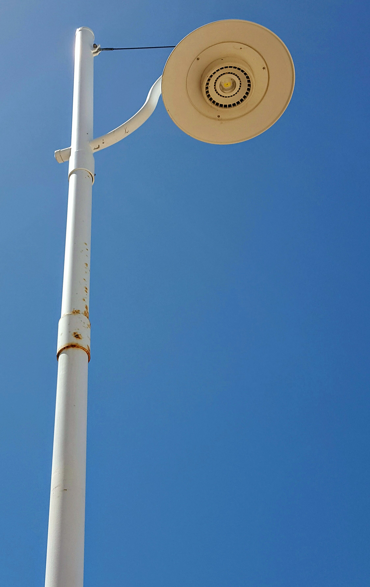 street light against bright blue sky background.