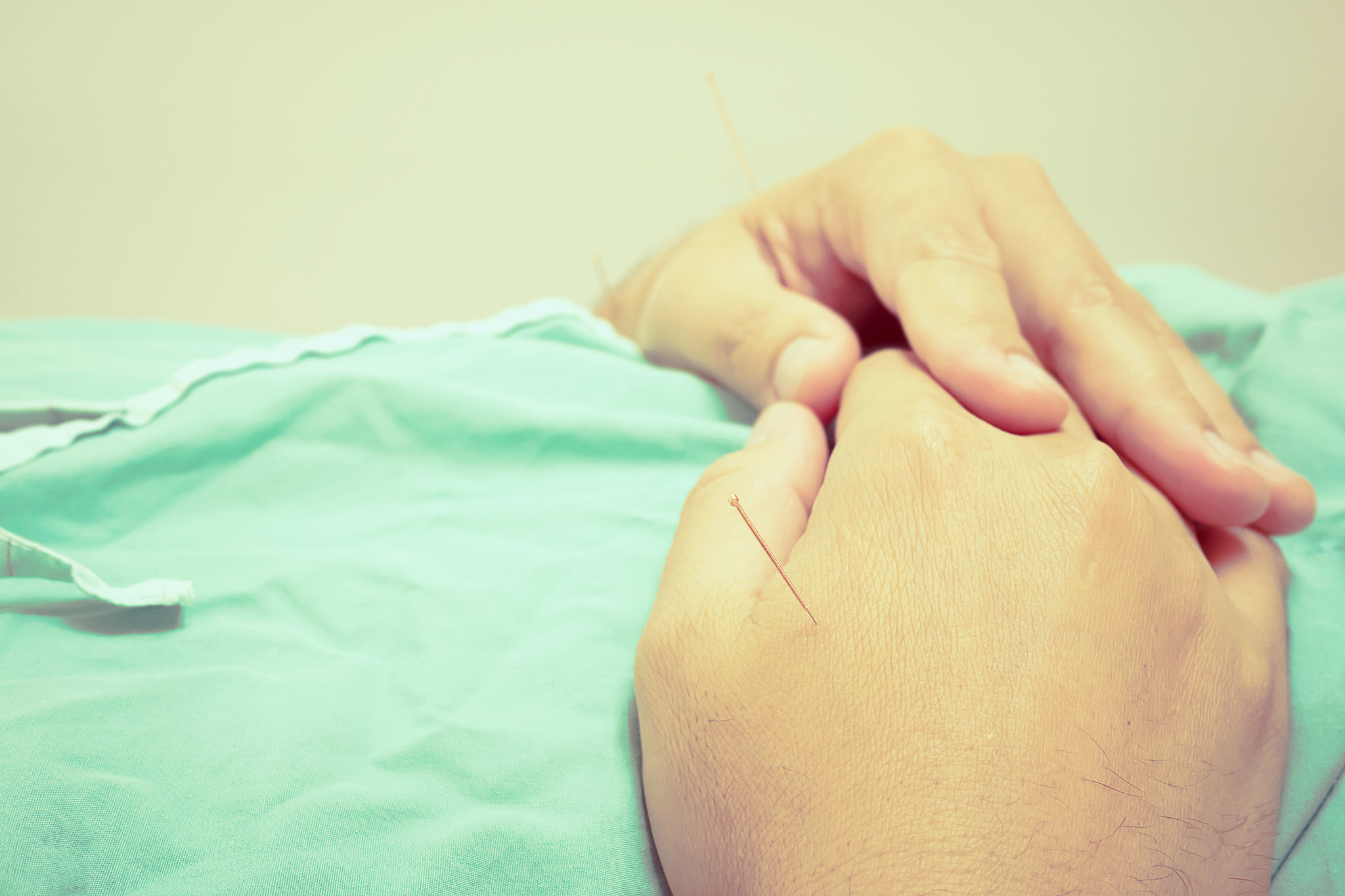 midsection of man with acupuncture needles in clinic