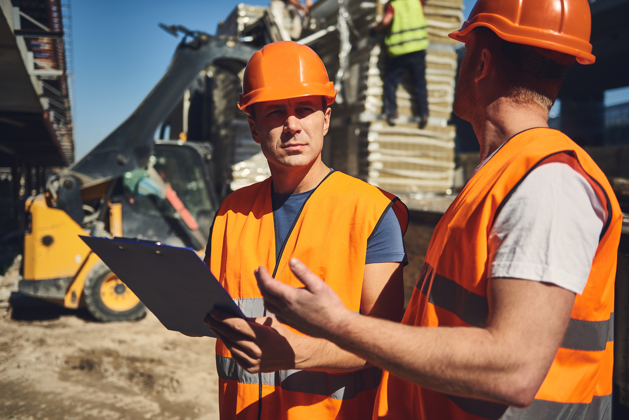thoughtful builder frowning and looking at his colleague
