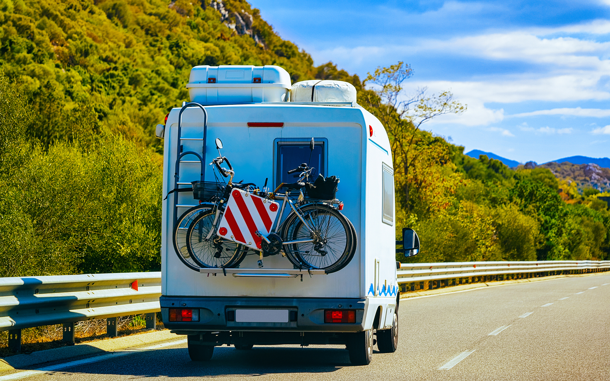 rv cavaran with bicycles on road in costa smeralda sardinia refl