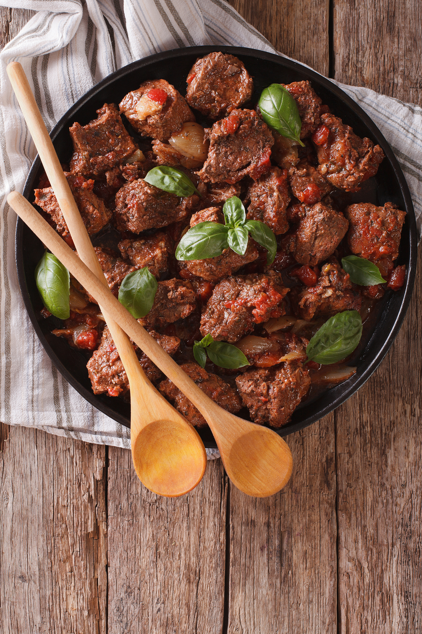 stifado beef with sauce and basil closeup. vertical