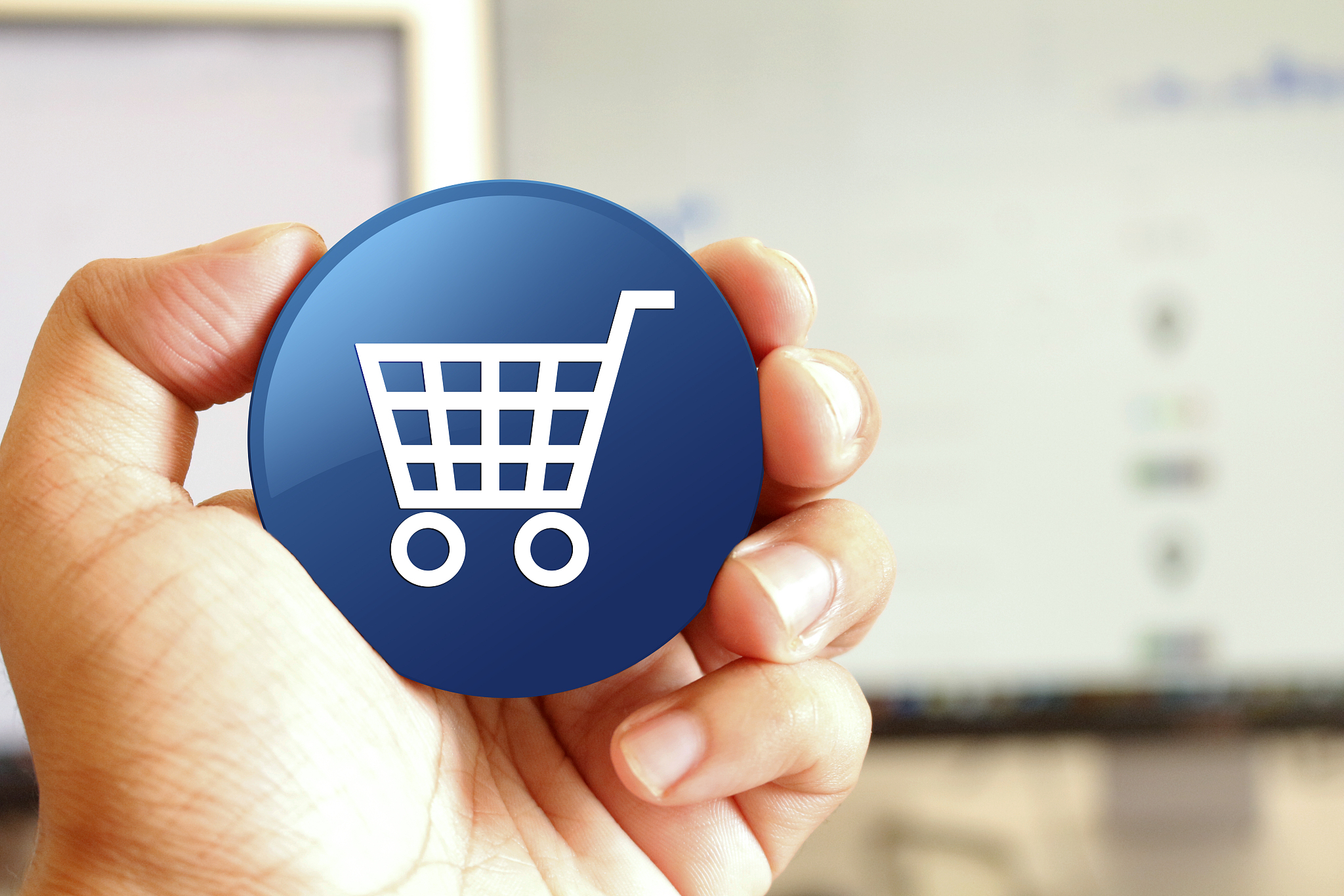 ecommerce icon blue round button holding by hand infront of work