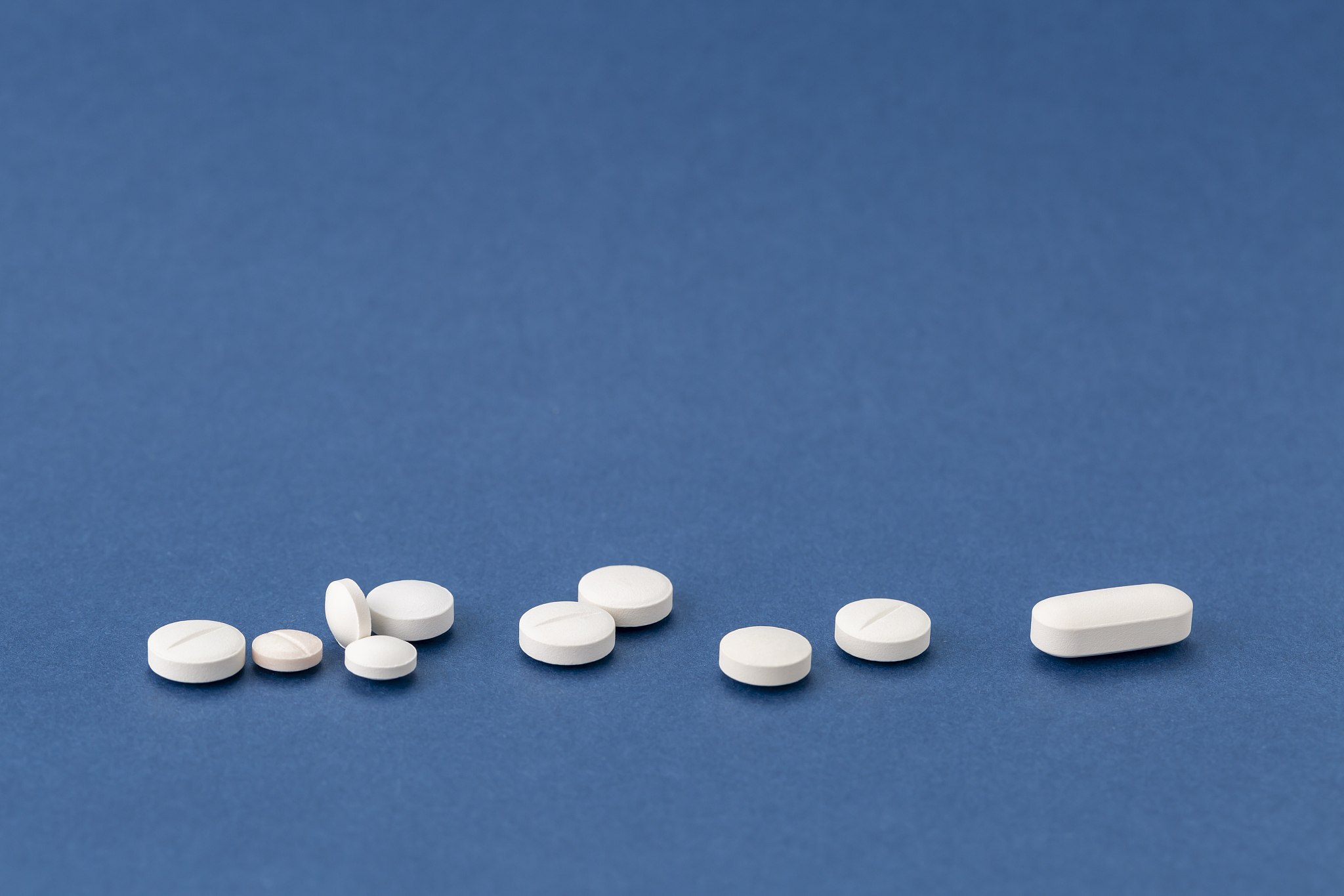 different white pills on blue background