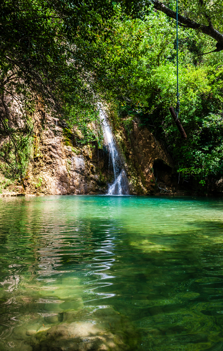 在幽深的峡谷中两岸树木茂盛碧绿的湖水上飘荡着淡淡的雾气偶尔有一叶轻舟在游荡岸边一间茅草屋屋边坐着一个弹古筝的美女根据描述作一首诗要求押韵。