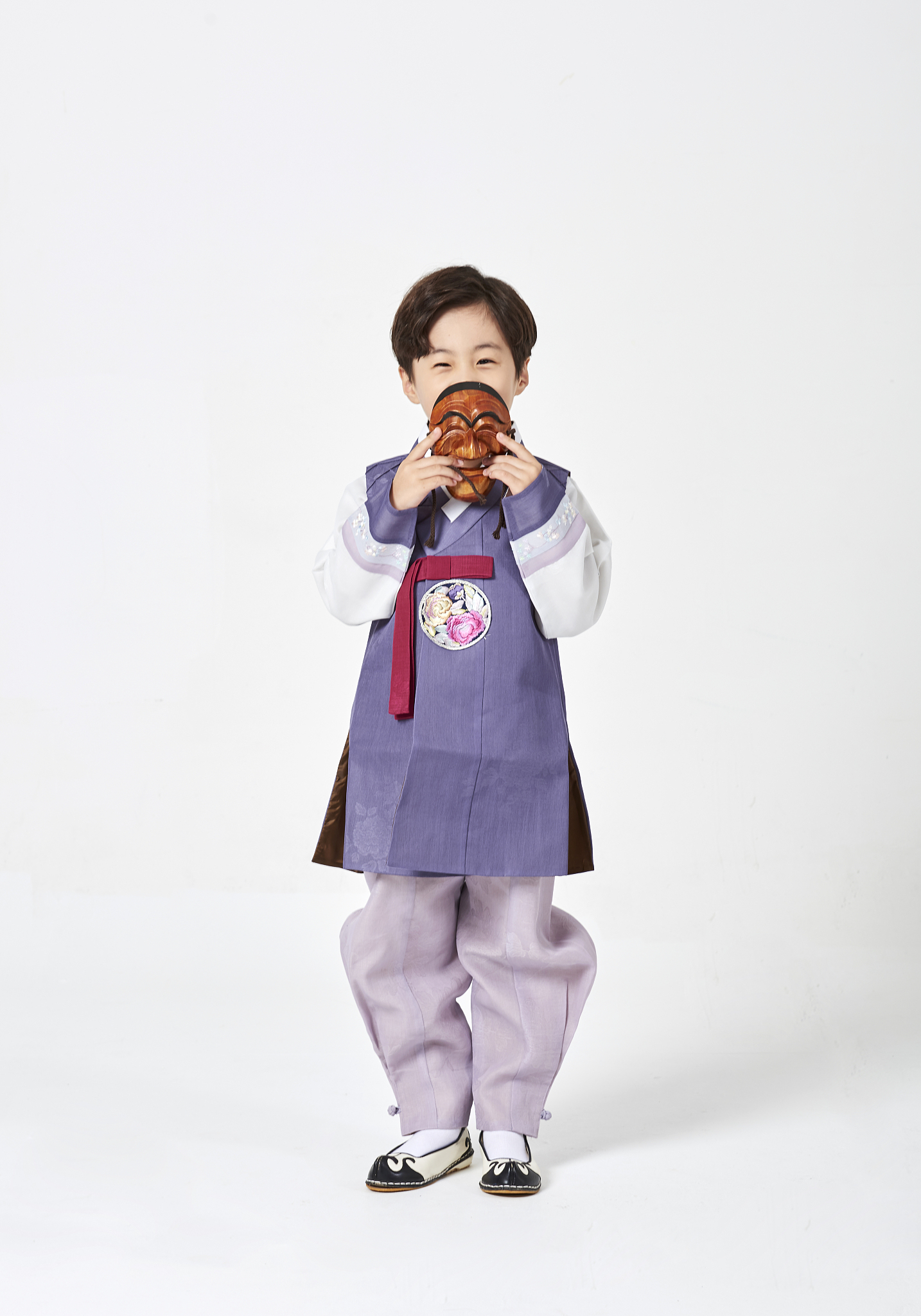 photography of boy wearing hanbok standing holding korean tradit