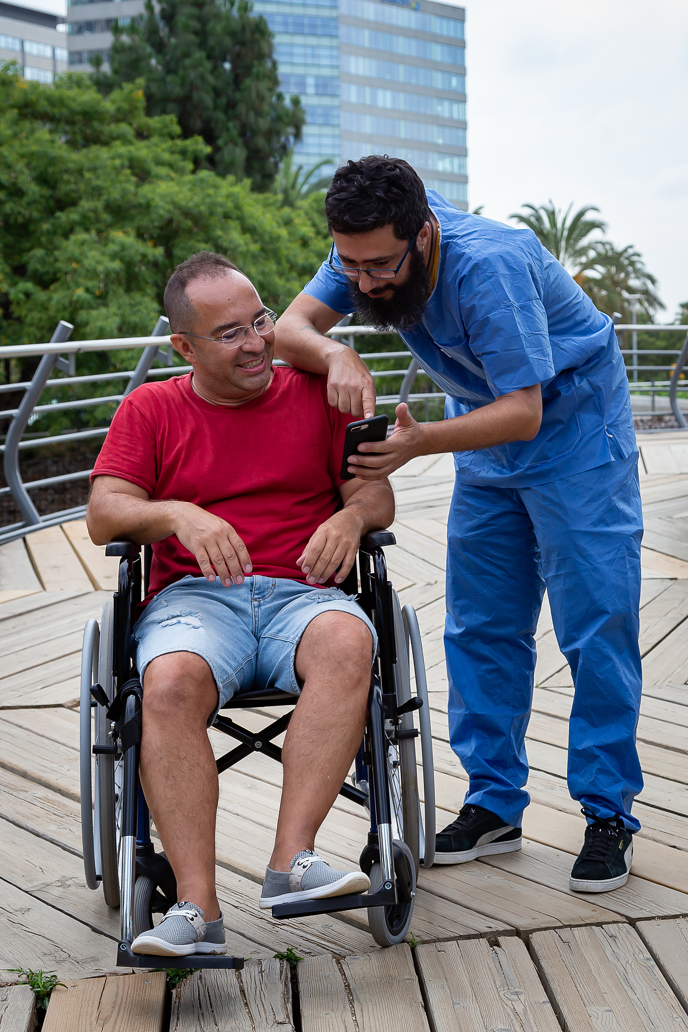disabled man in a wheelchair talking with his caretaker
