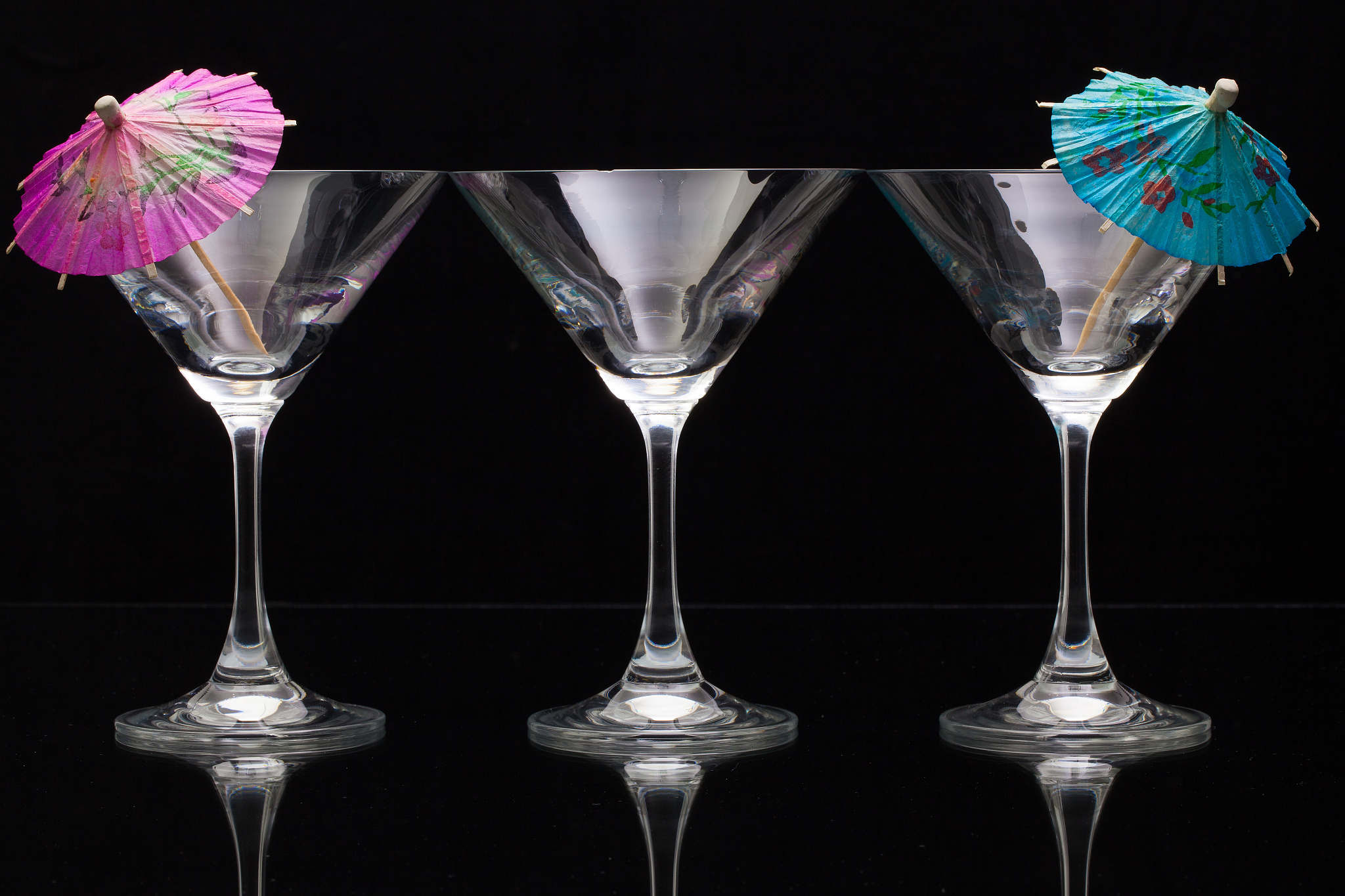 three empty glasses of champagne with paper umbrellas