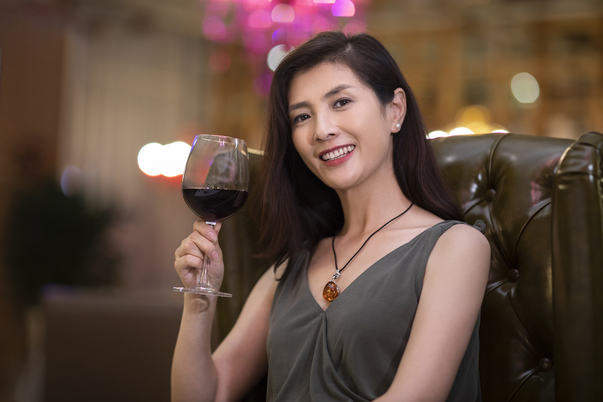 优雅女士在餐厅品尝红酒