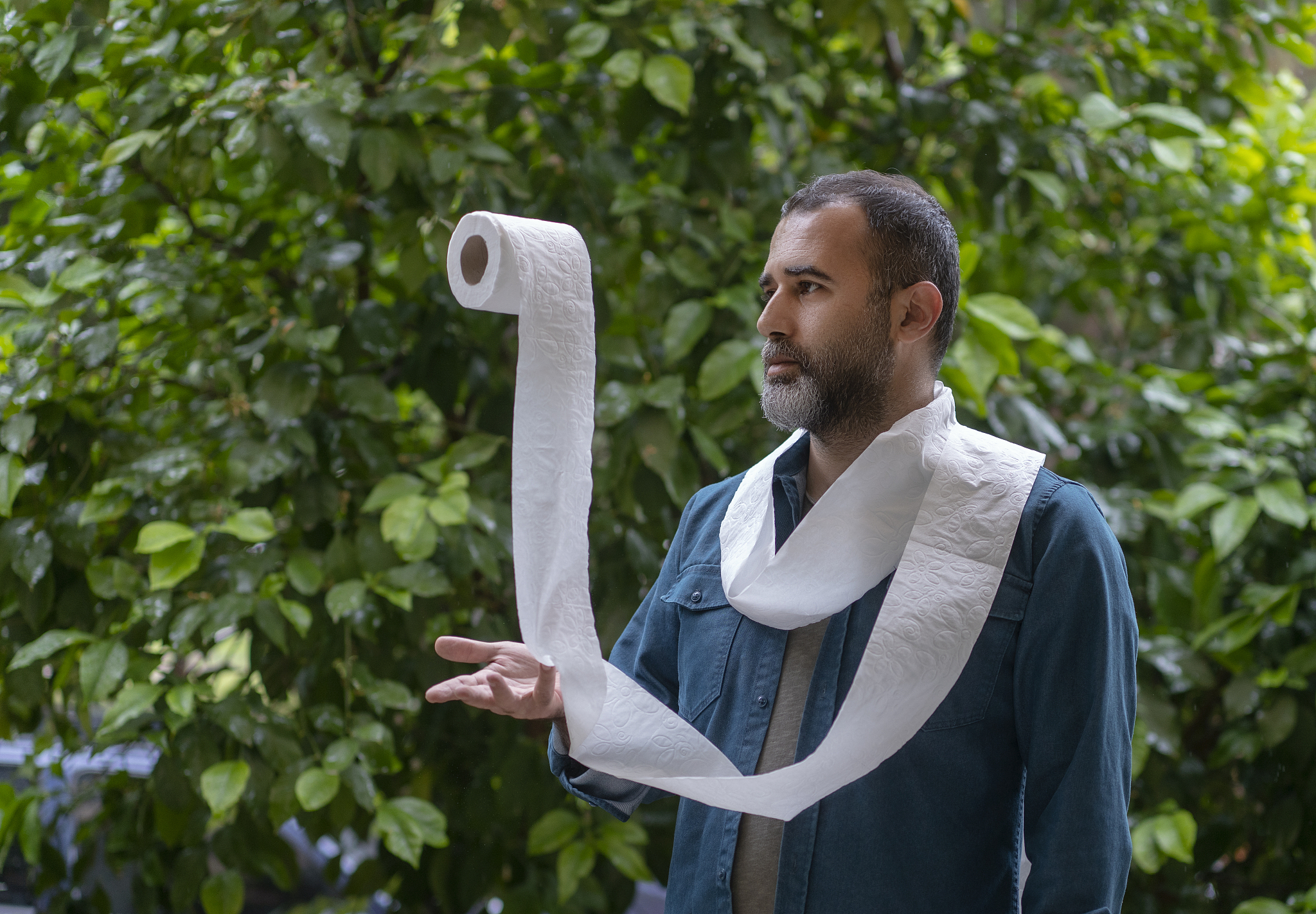 man juggling with toilet papers at the garden