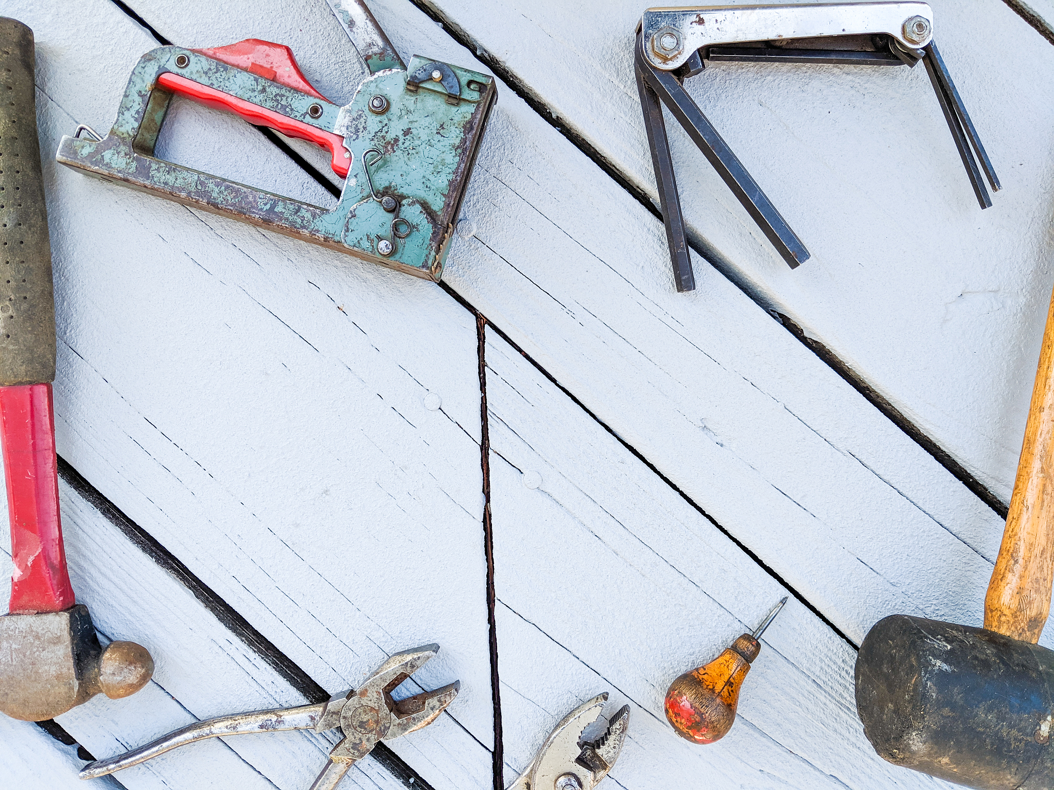 flat lay of old tools against a rustic painted wooden background