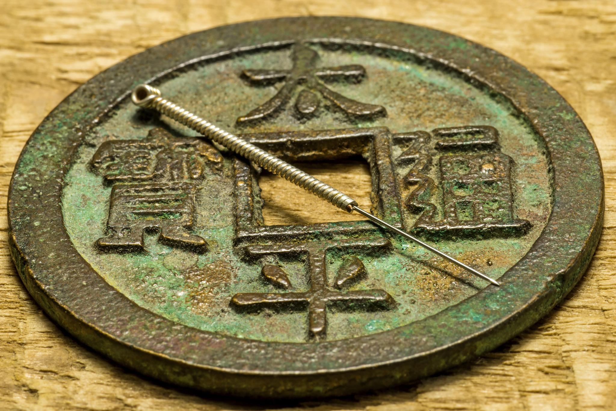 acupuncture needles on chinese coin