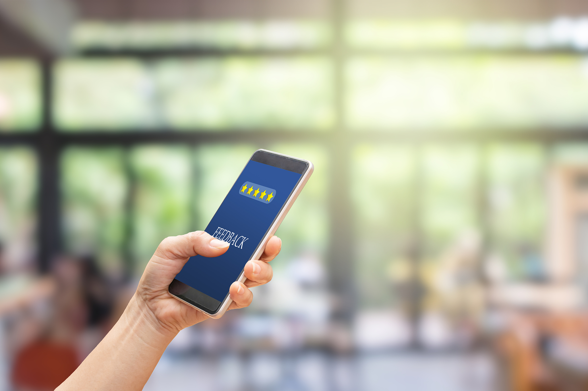 hand pressing feedback button on smartphone for giving best serv
