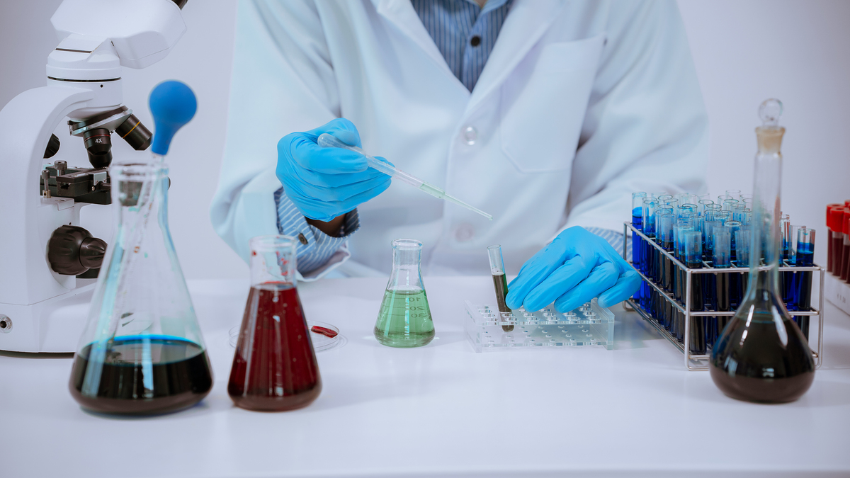 科学:医生在实验室里拿起试管进行分析,技术人员穿着