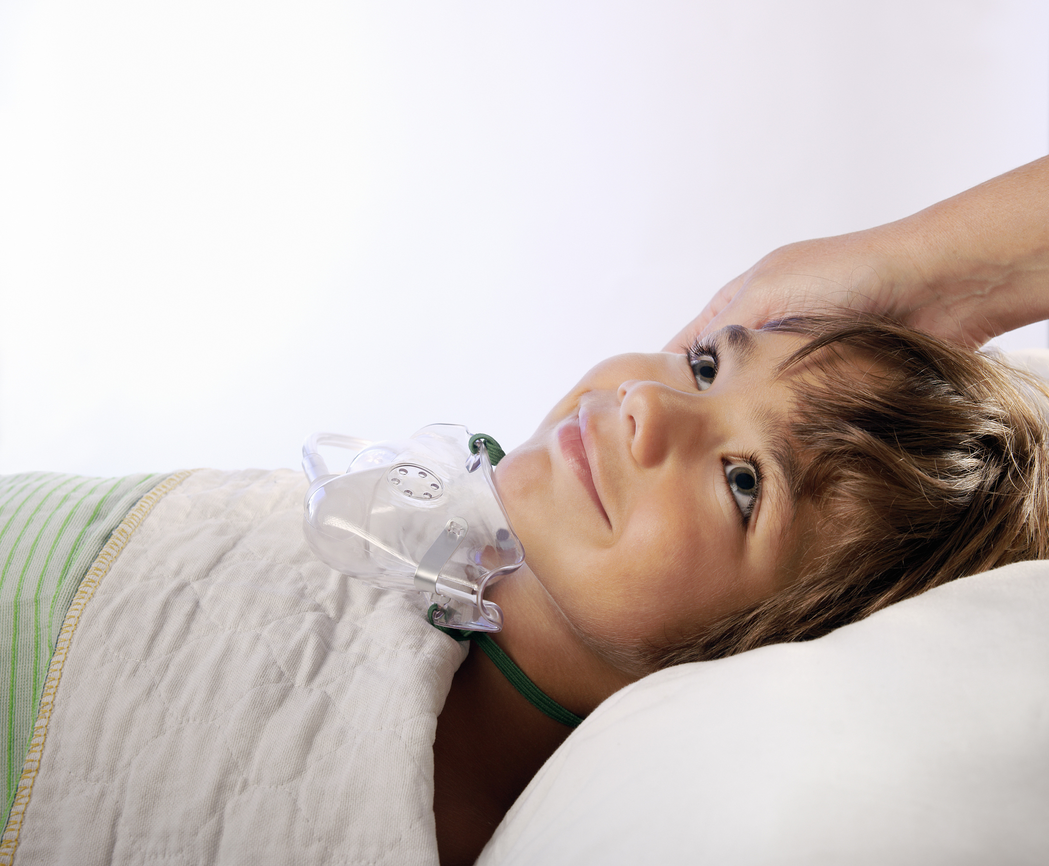 smiling little boy with an oxygen mask in hospital