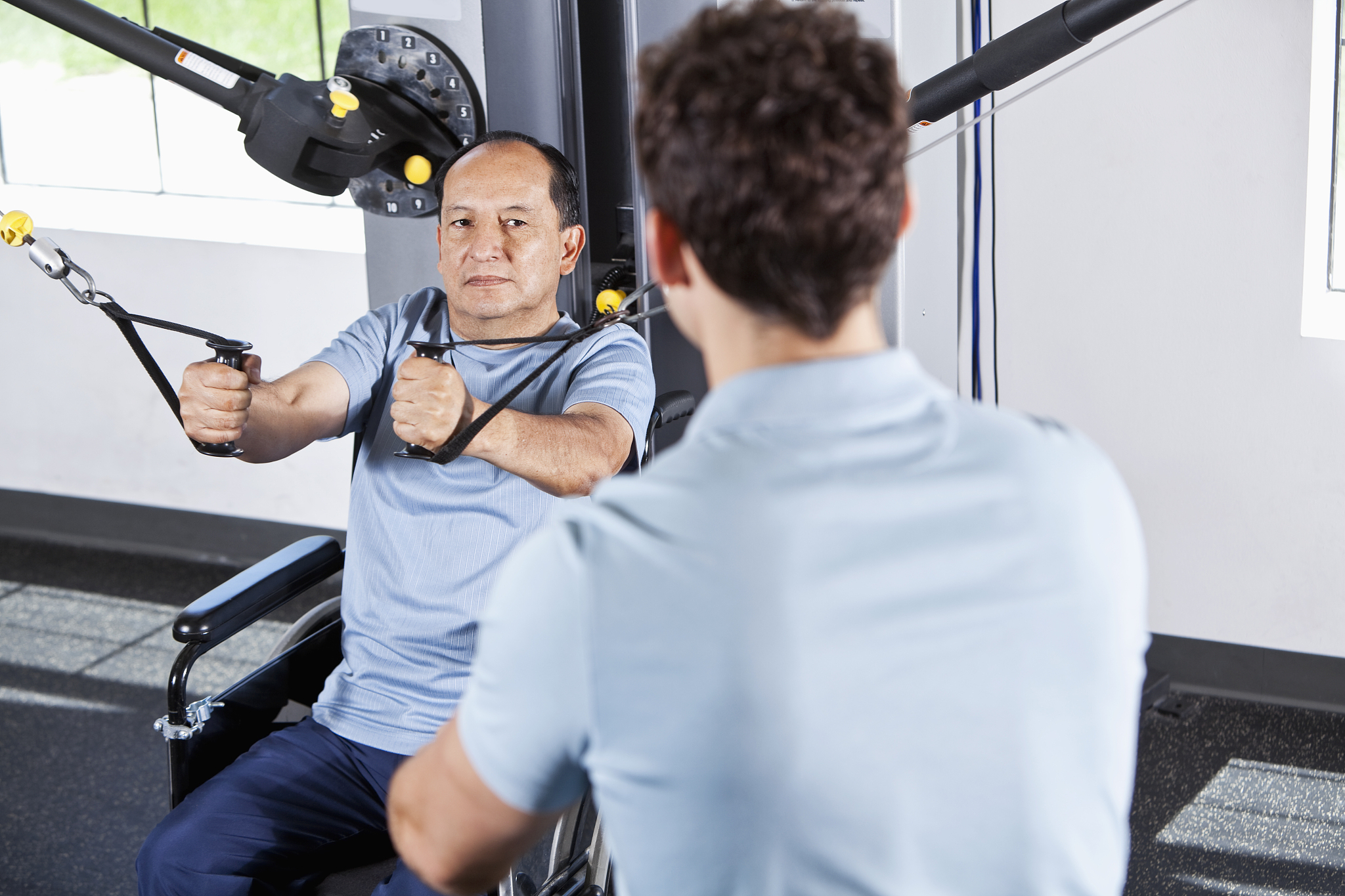 physical therapist helping patient in wheelchair