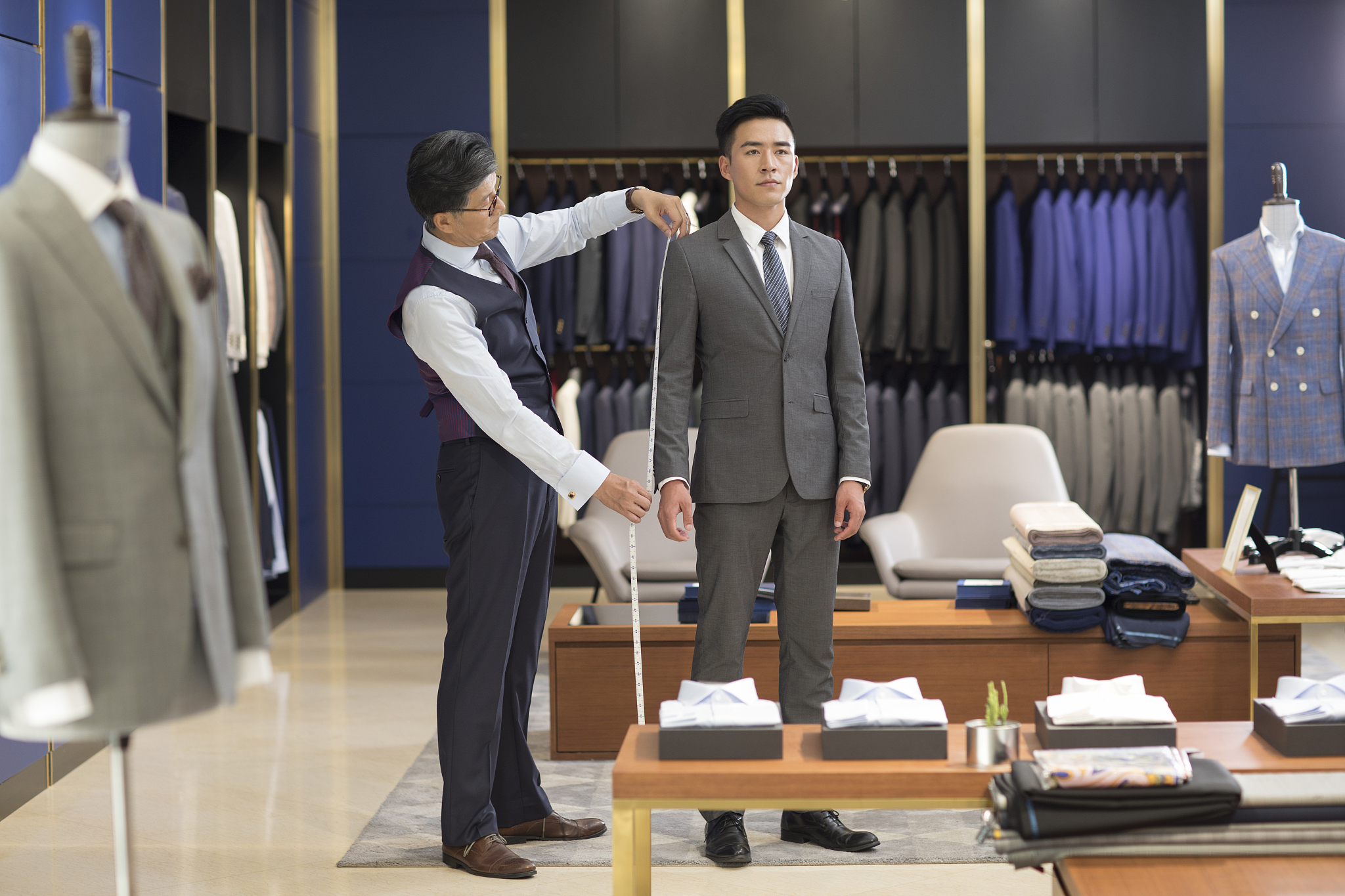 服装设计师为顾客量尺寸