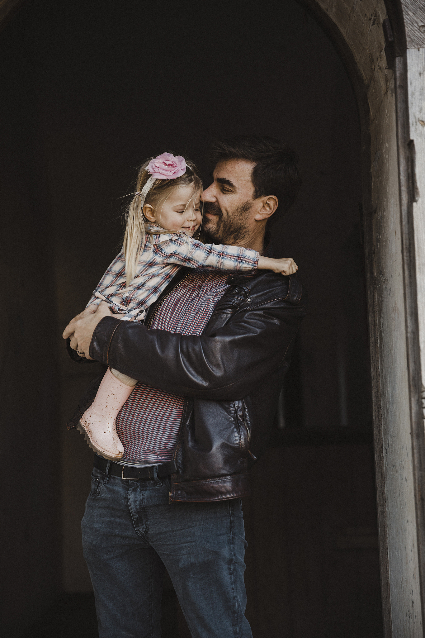 father hugging young daughter in doorway