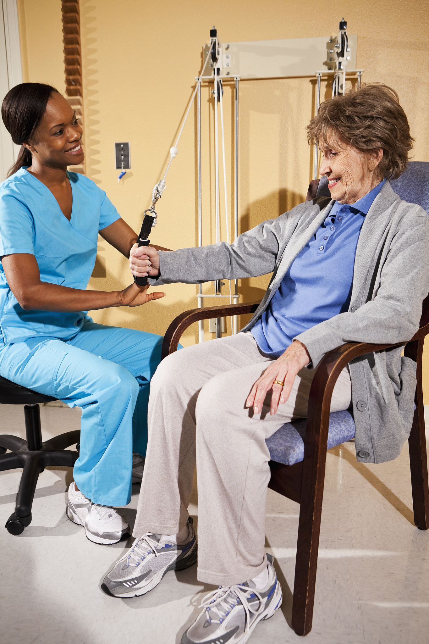 physical therapist working with patient on upper extremity exerc