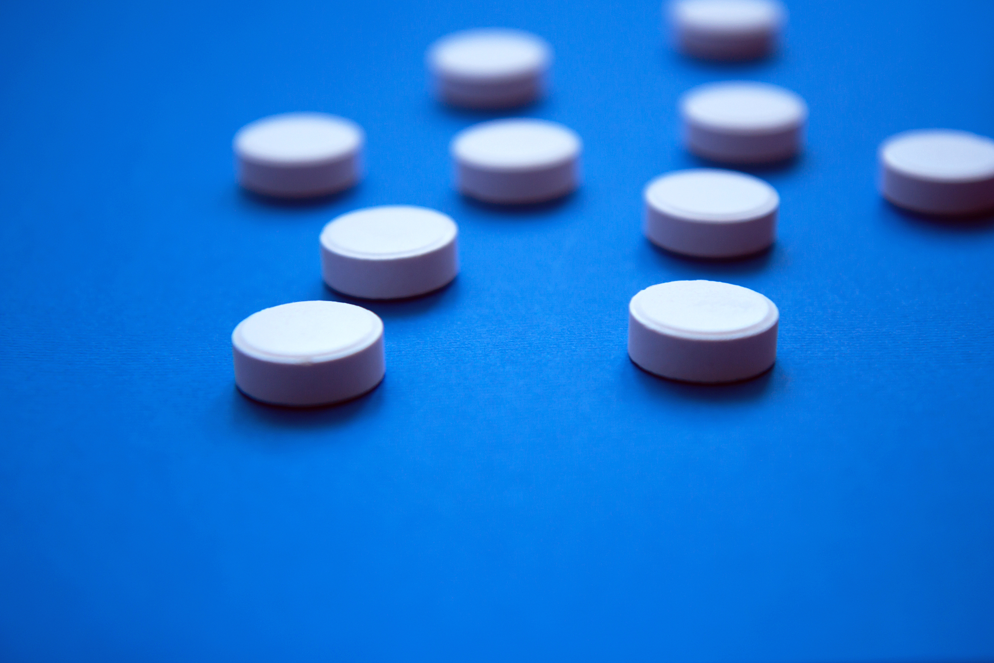 set of white pills on blue background