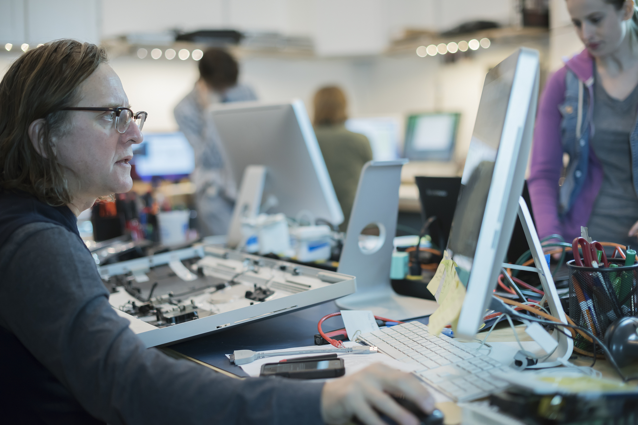 a man seated at a computer, looking at the screen. computer repa