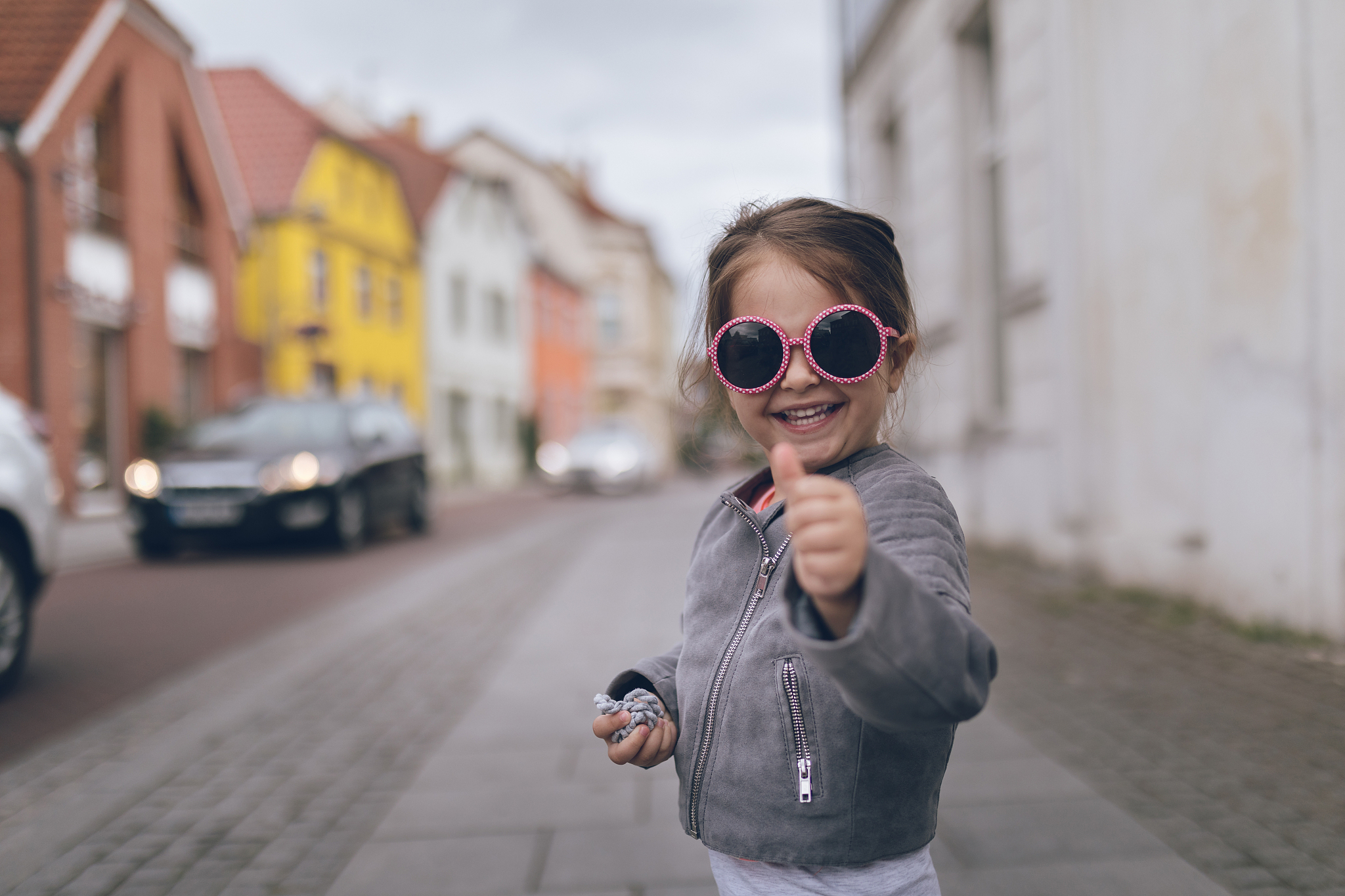 smiling toddler holding a thumbs up