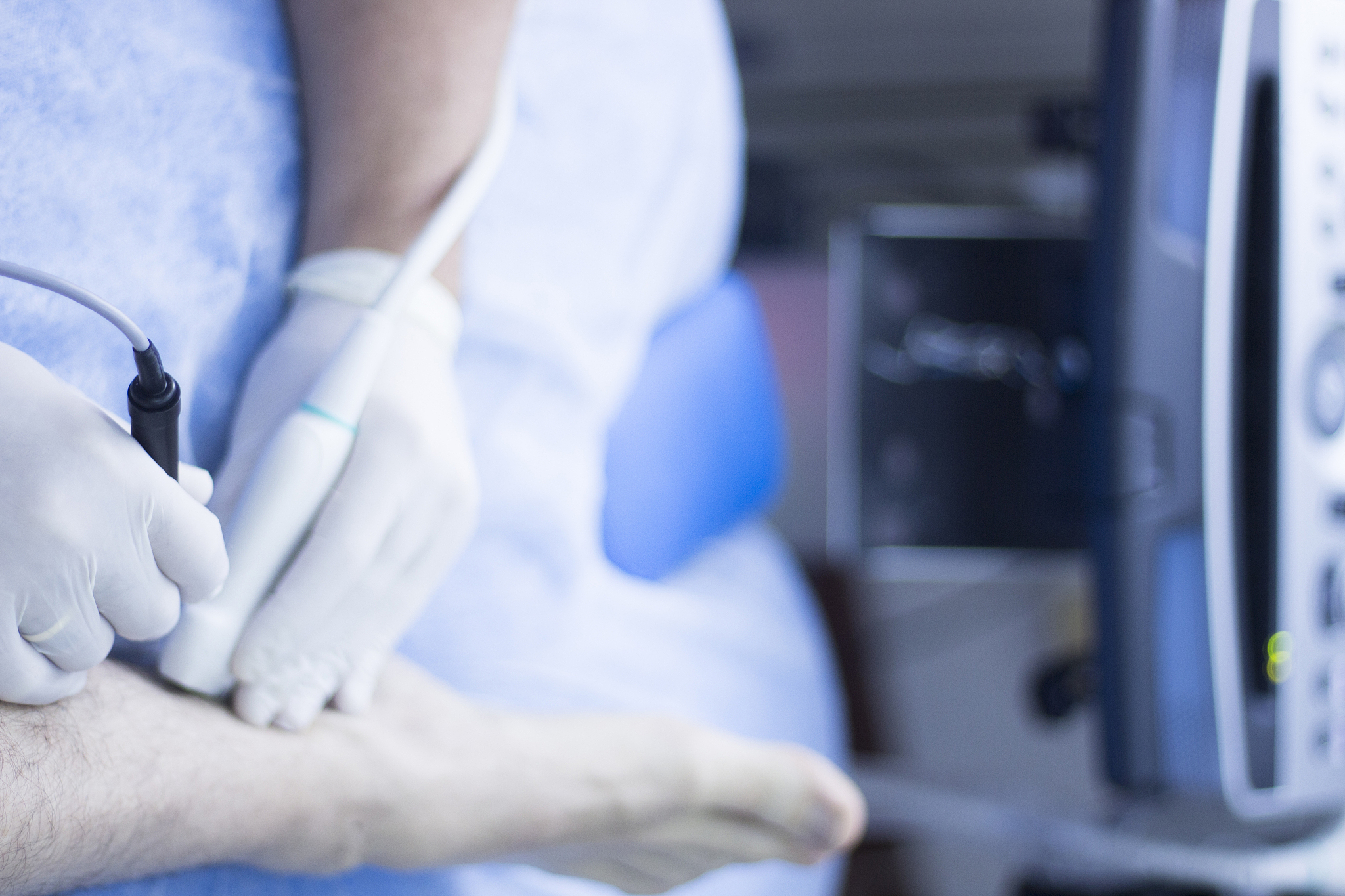 midsection of doctor examining patient leg in hospital