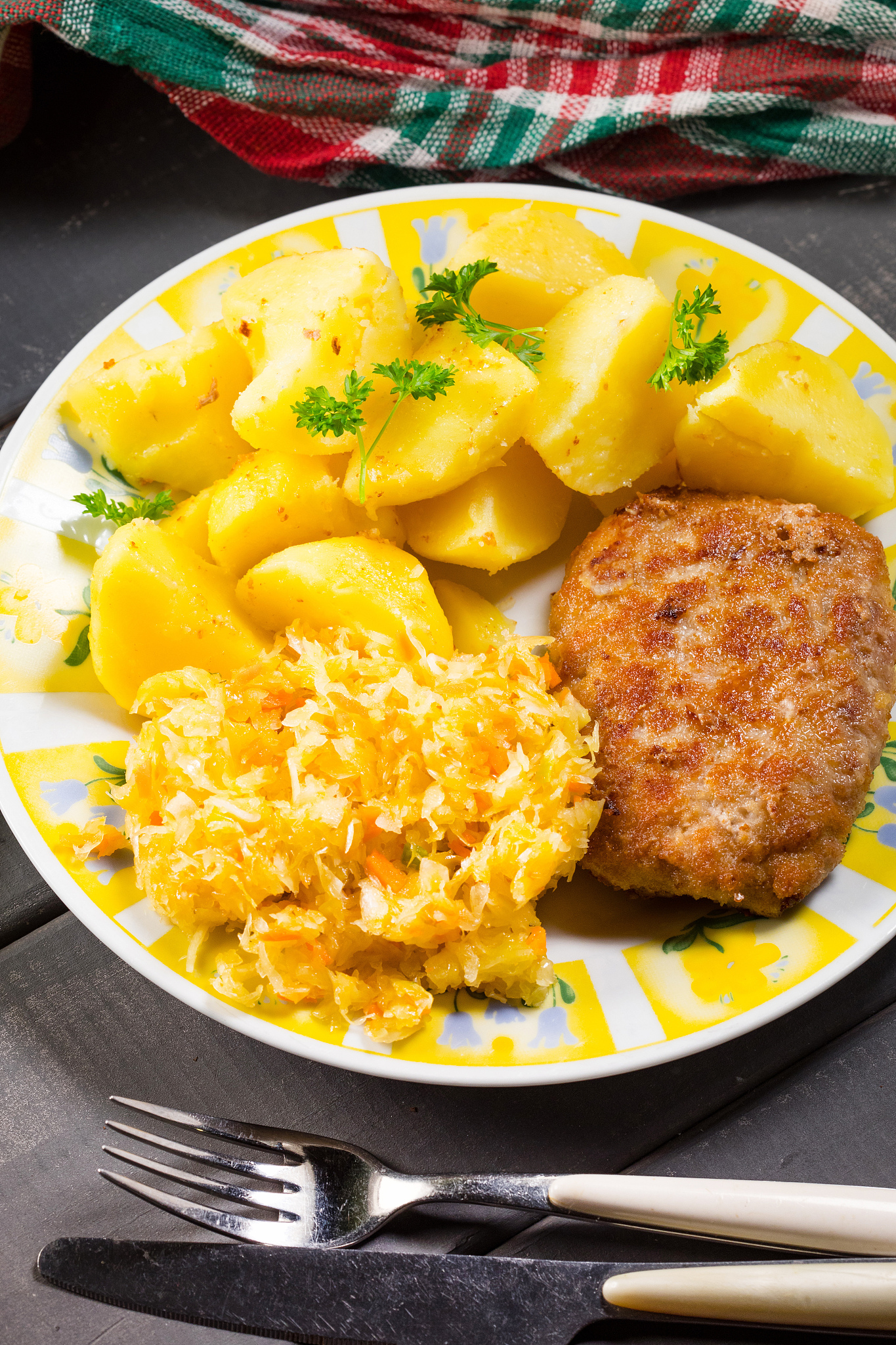 minced pork cutlet served with potatoes and sauerkraut salad.