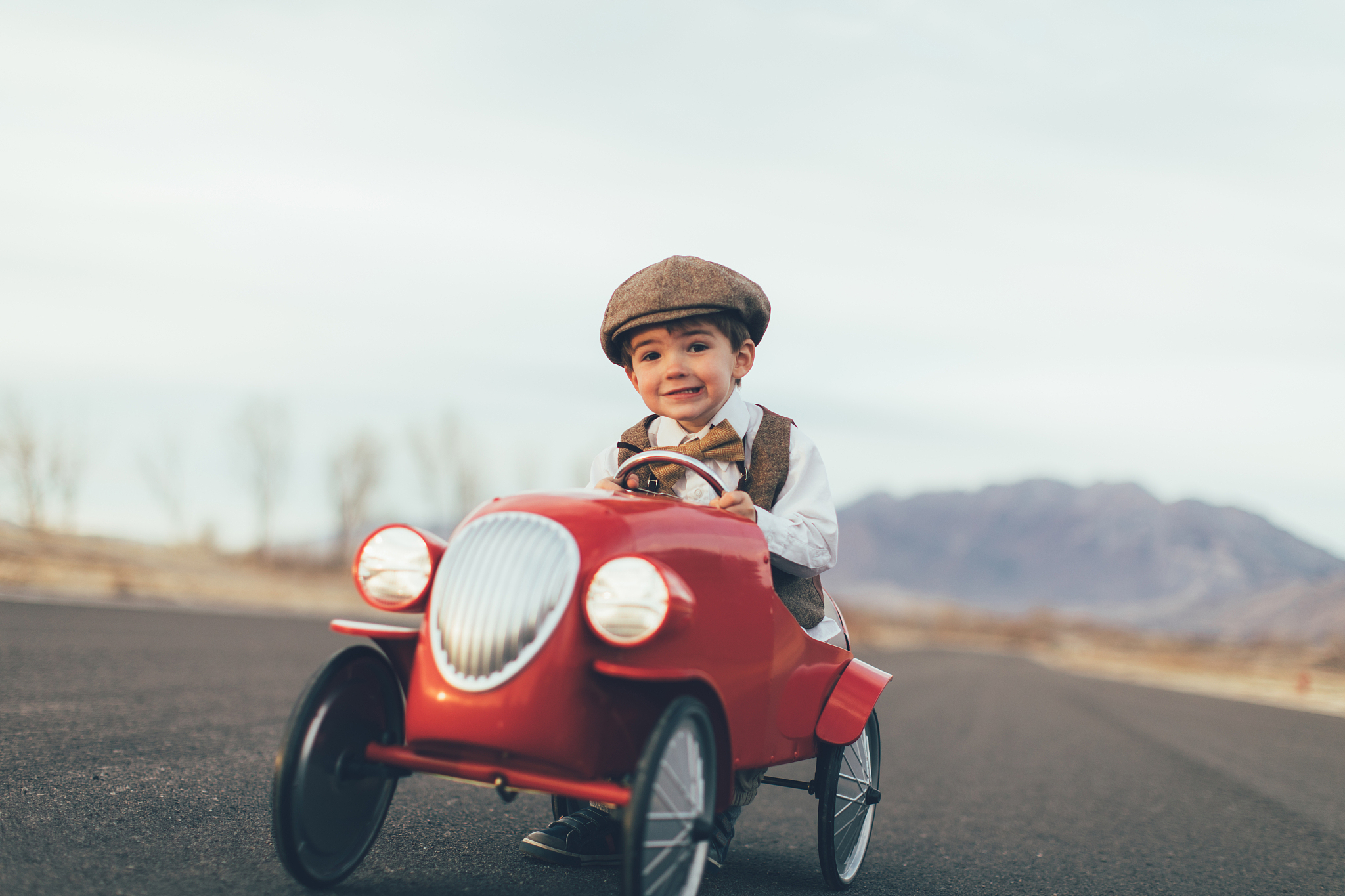 young vintage boy drives toy car