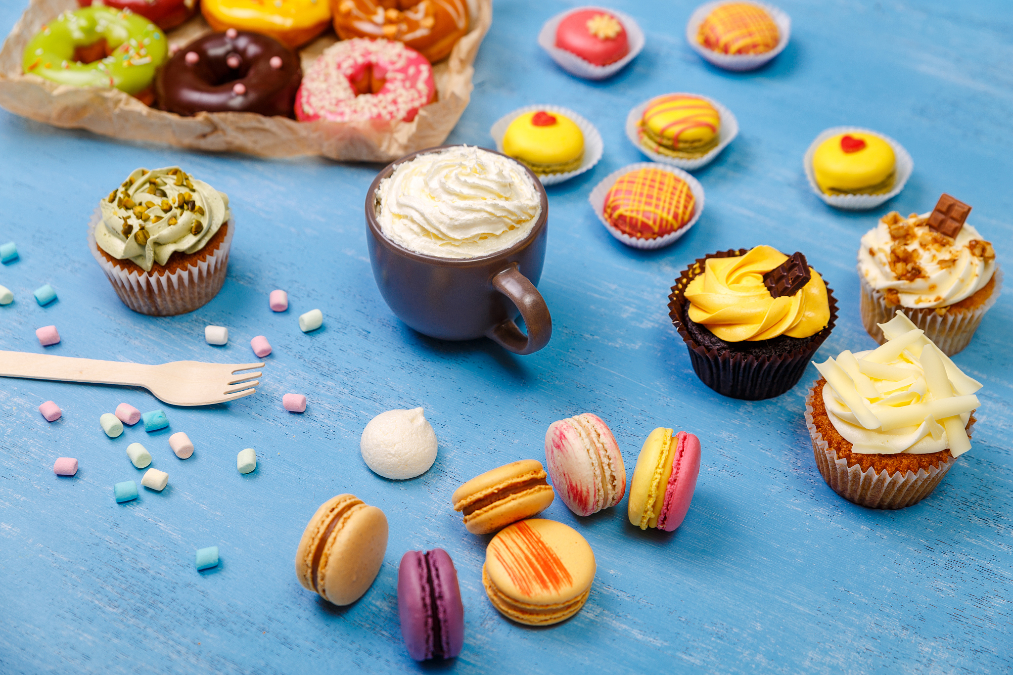 macaroons, cupcakes and donuts. mug with cream.